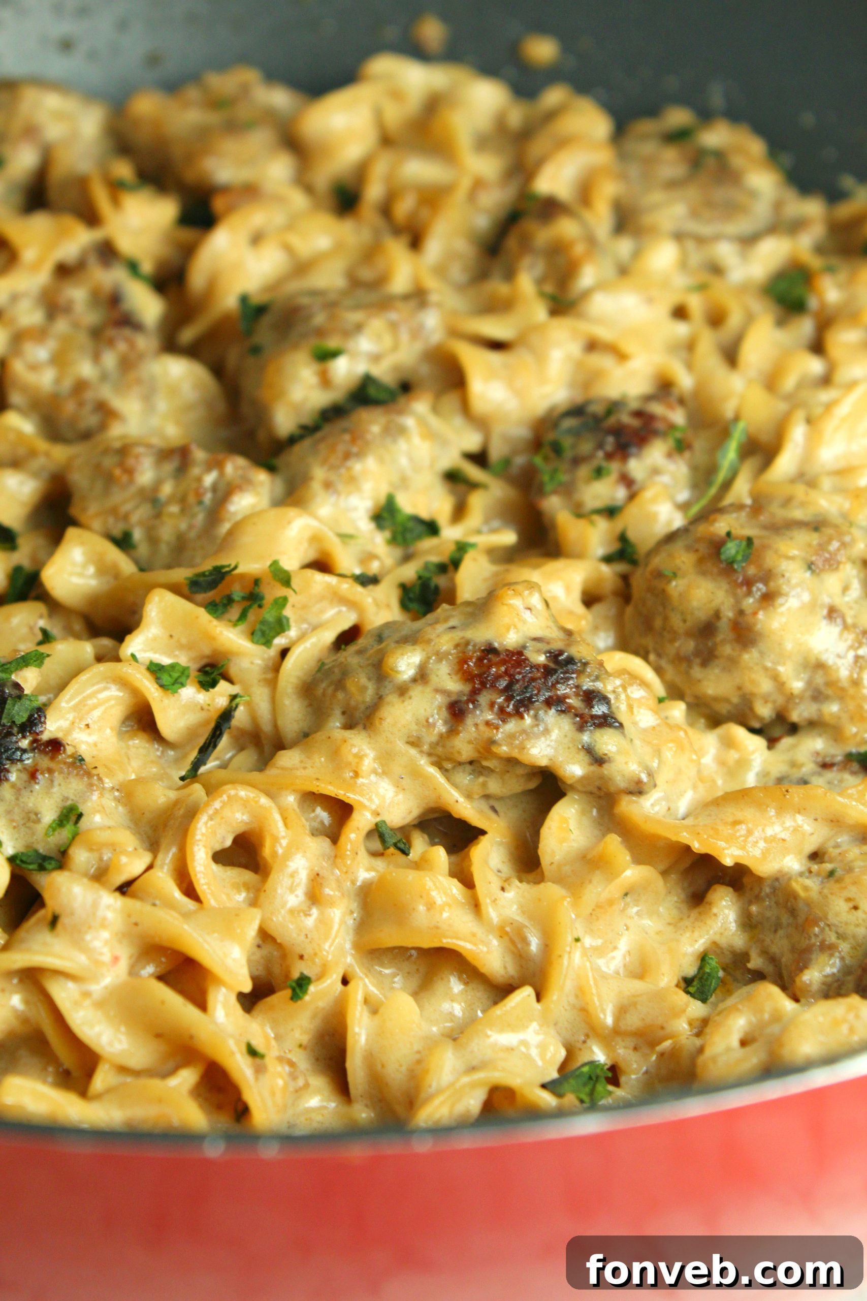 Velvety French Onion Sausage Pasta 2 A top-down view of Creamy French Onion Sausage Pasta in a large skillet, garnished with fresh parsley.