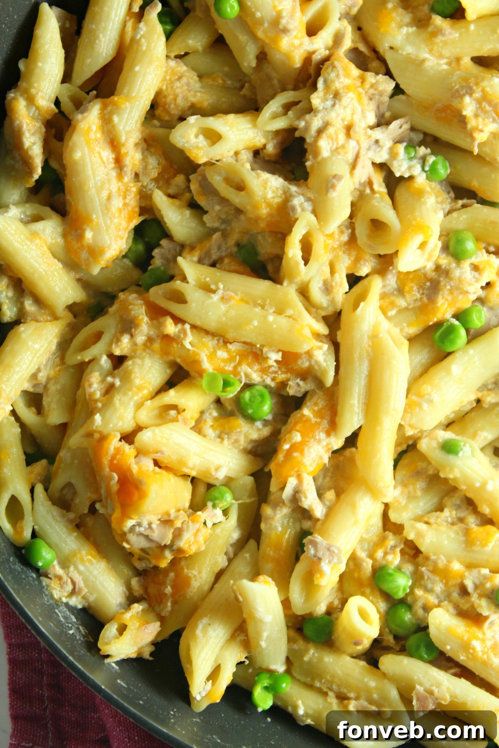 Golden Tuna Cheese Bake 7 Close-up of Cheesy Tuna Casserole with vibrant green peas visible, emphasizing the fresh ingredients.