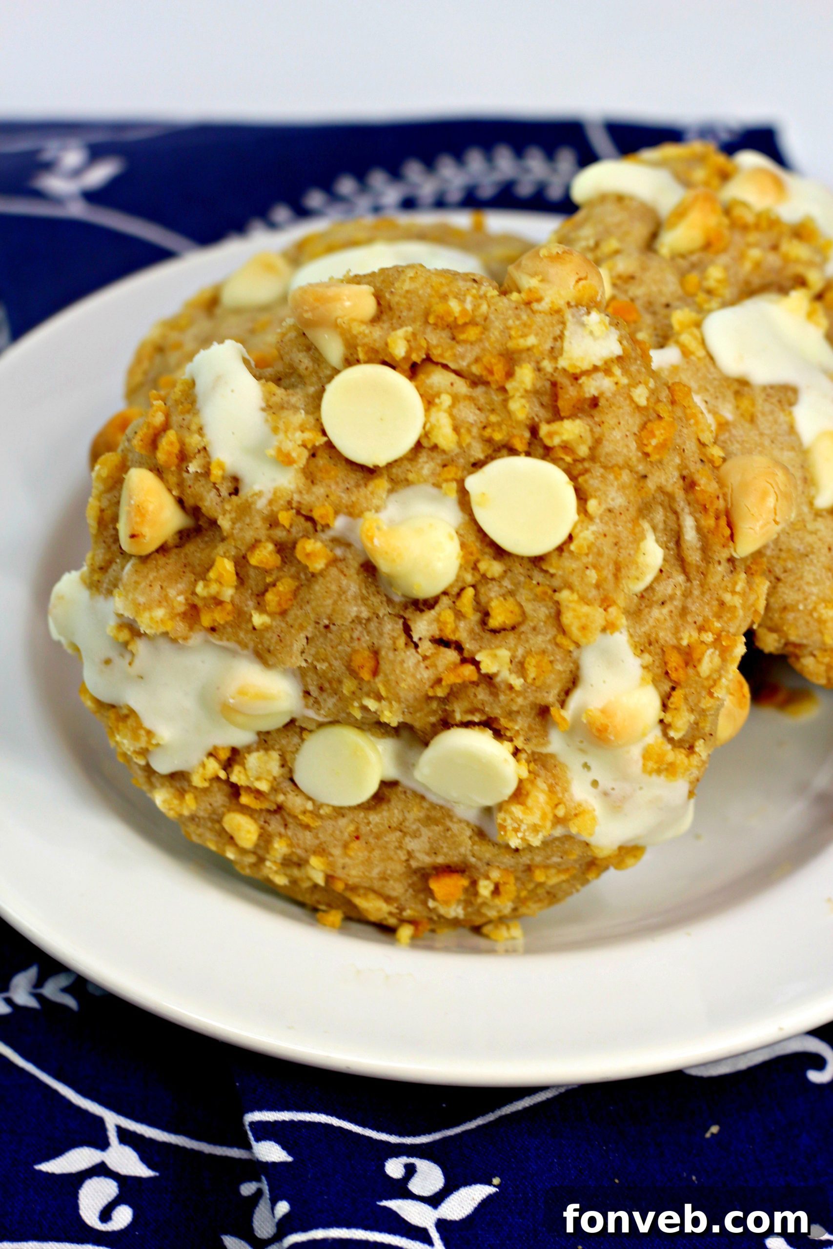 Decadent Cinnamon Roll Stuffed Cookies 4 Cinnamon roll cookies with a bite taken out, revealing the creamy filling.