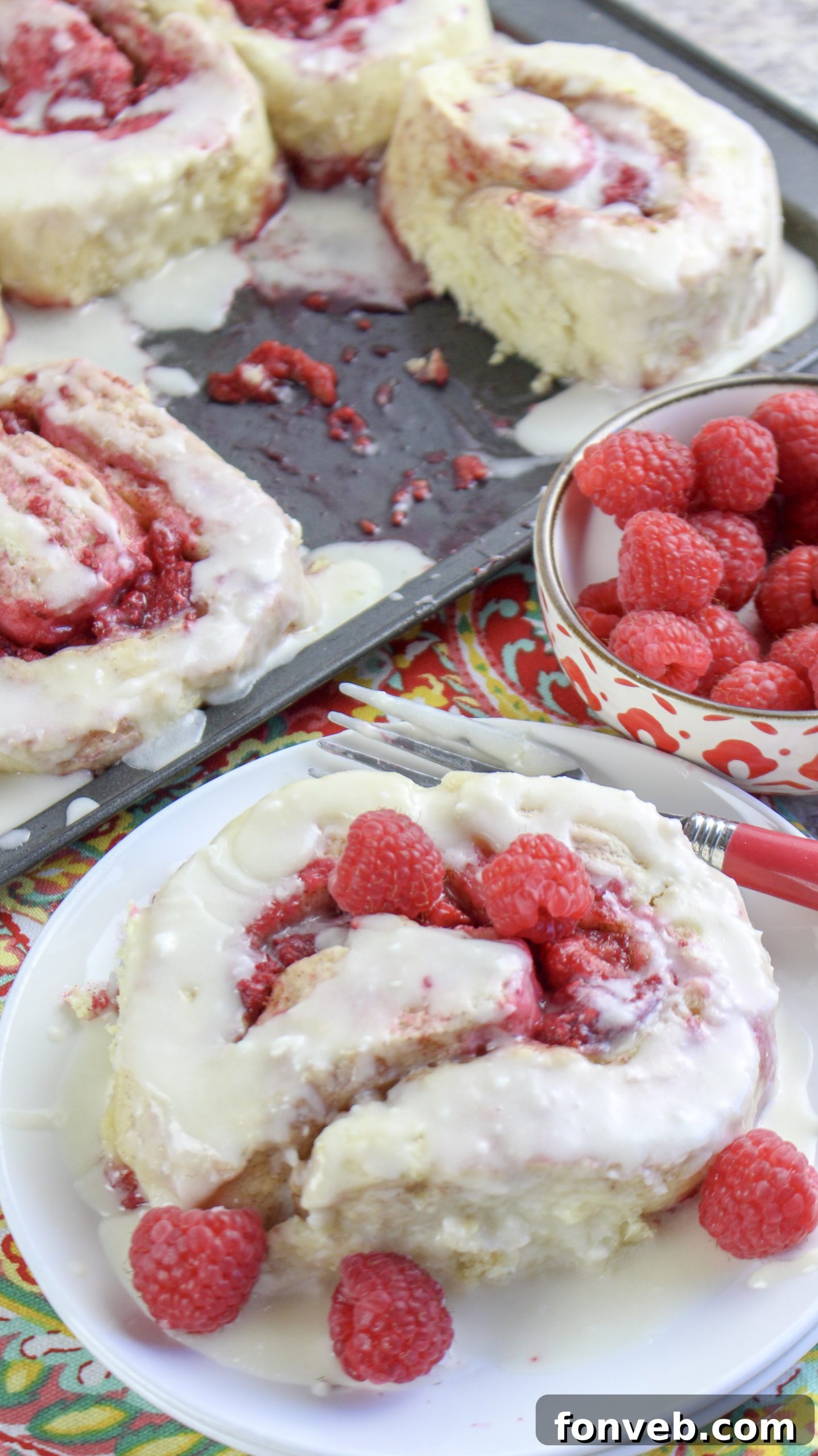 Velvet Raspberry Cinnamon Rolls 10 A close-up shot of an individual raspberry cinnamon roll, showcasing its fluffy texture and rich filling.