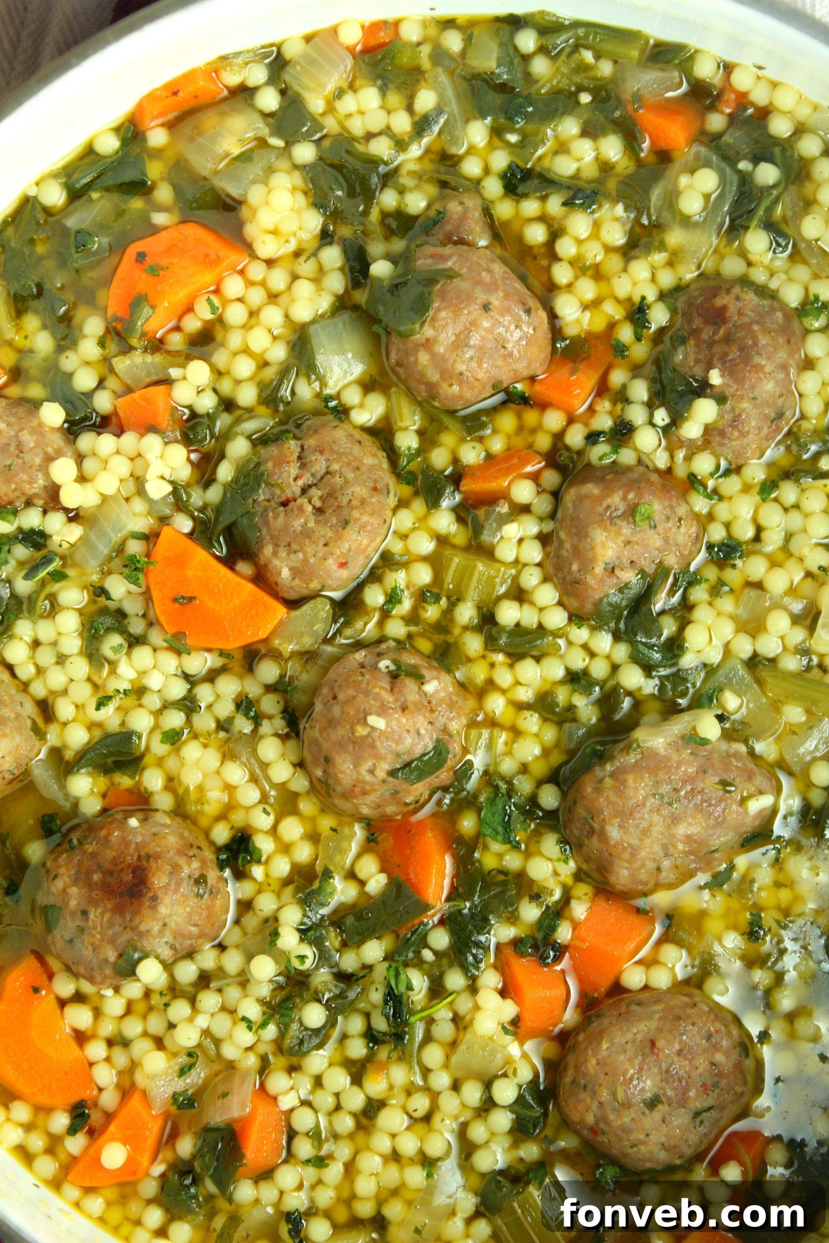 A bowl filled with the raw ingredients for Italian Wedding Soup meatballs, including ground beef and pork, breadcrumbs, and fresh herbs, ready for mixing.