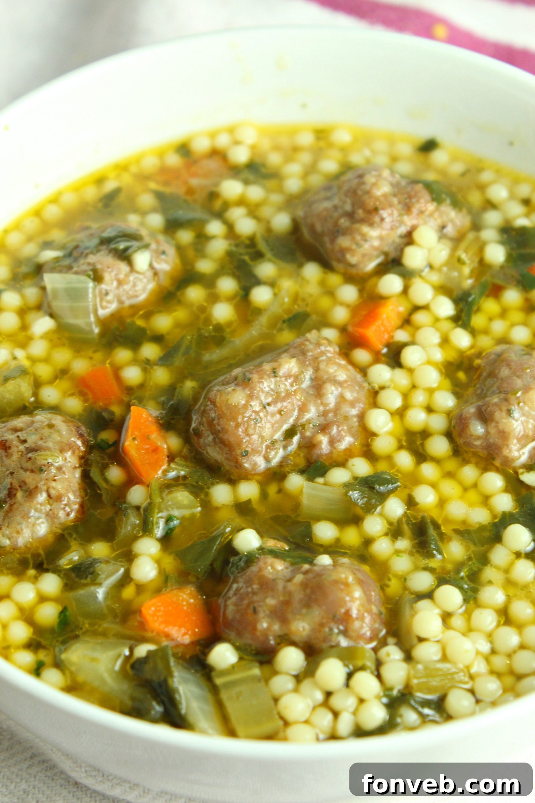 Fresh, vibrant green leafy vegetables, including escarole, baby spinach, and kale, neatly arranged and ready for use in Italian Wedding Soup.