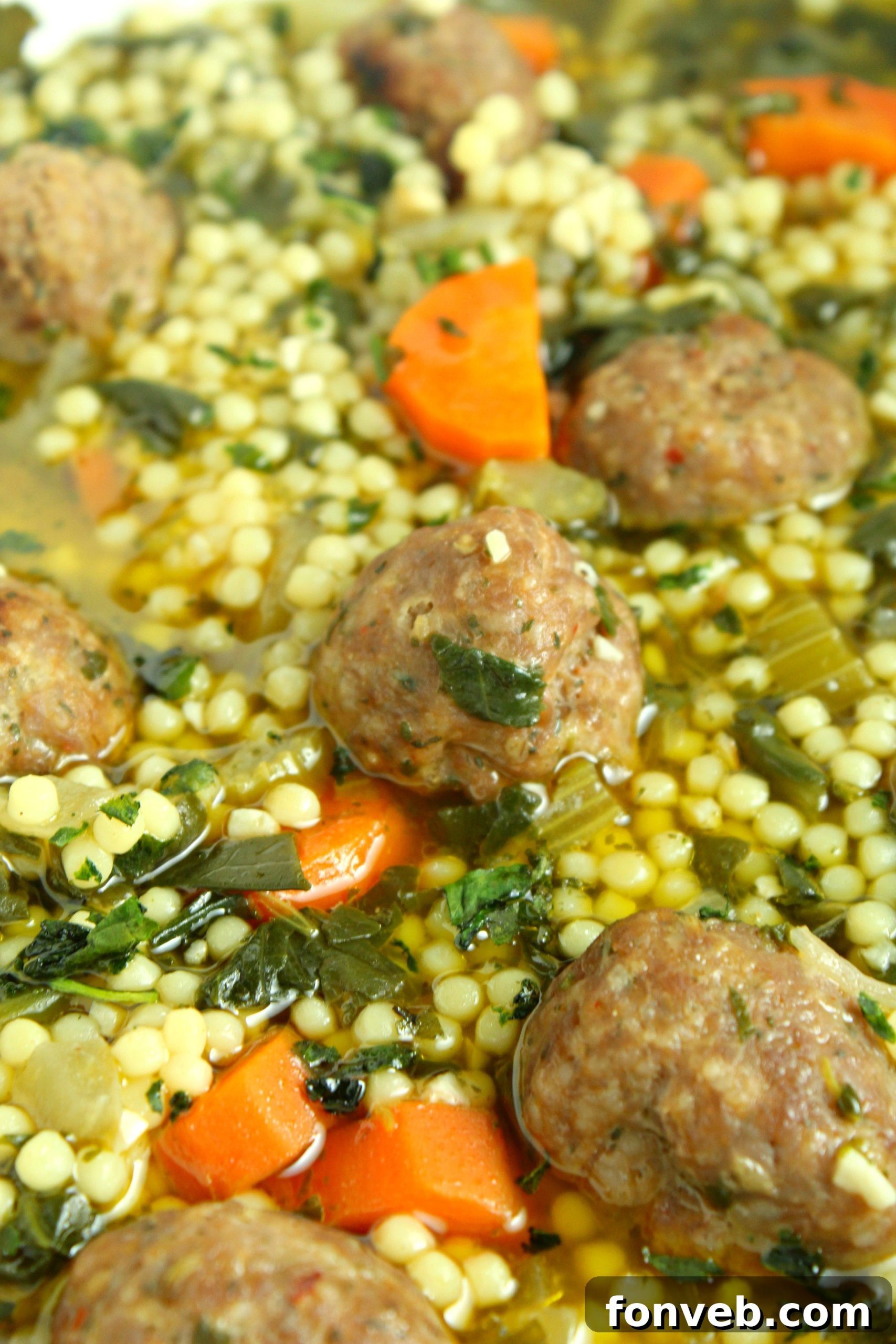 A generous serving of homemade Italian Wedding Soup in a rustic bowl, topped with grated Parmesan and accompanied by a slice of crusty bread, symbolizing comfort food.