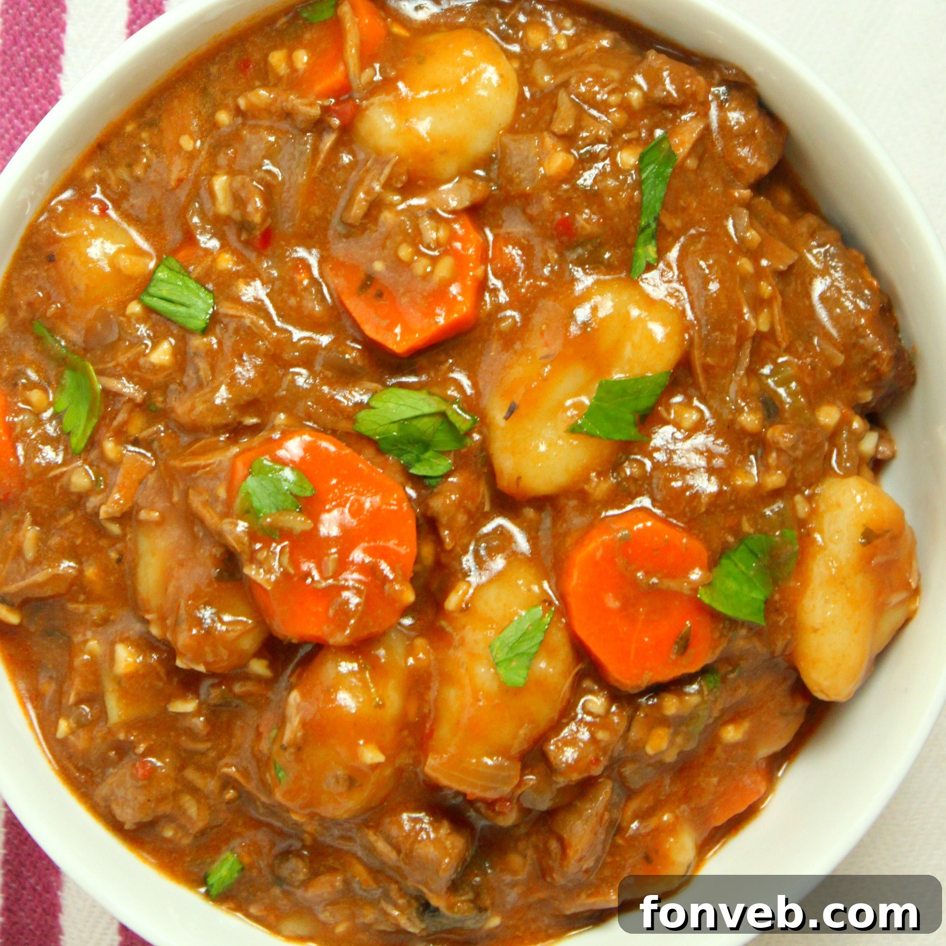 A family enjoying bowls of chunky beef and gnocchi soup together, smiling.
