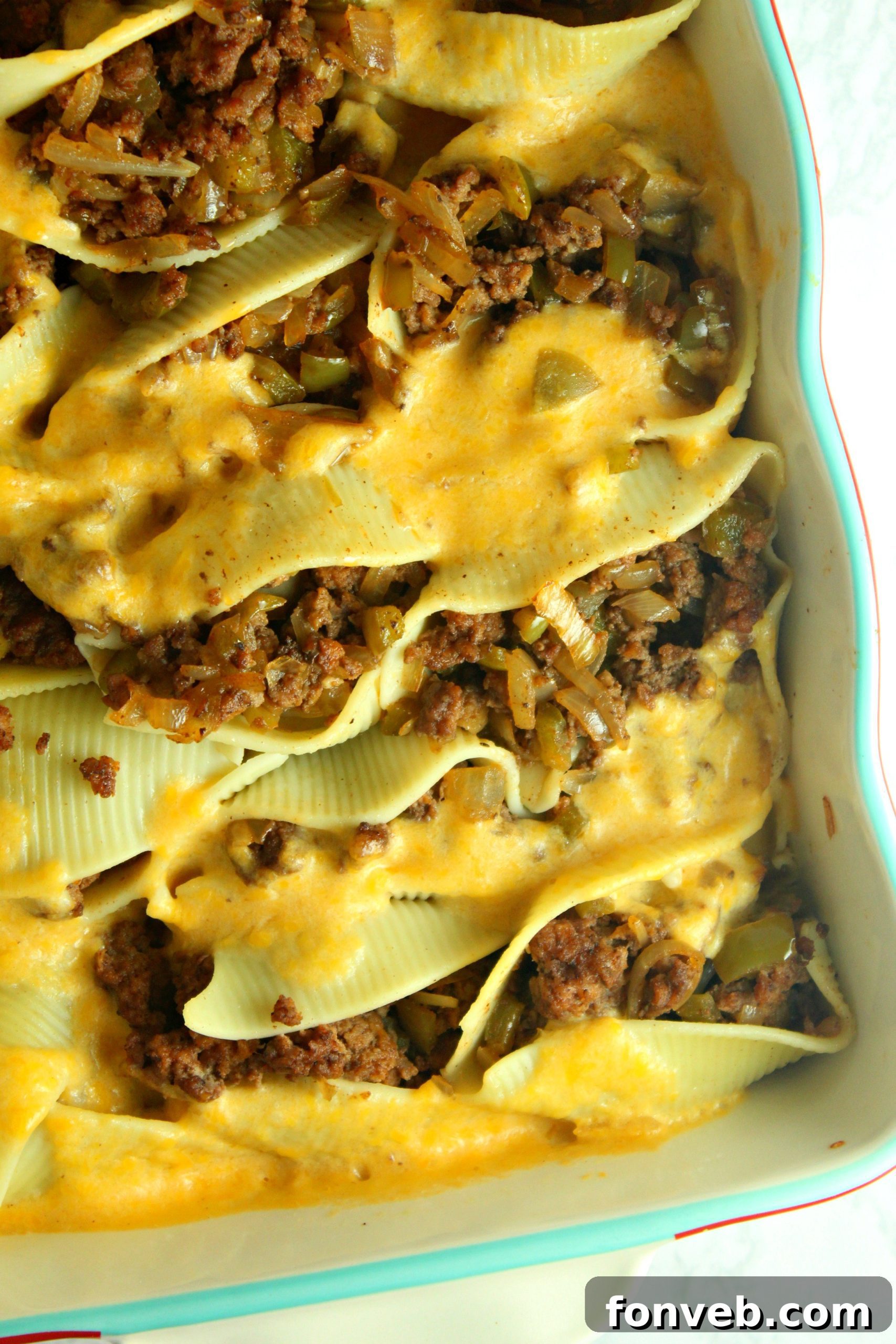 Stuffed pasta shells arranged in a baking dish before being baked, highlighting the generous filling.