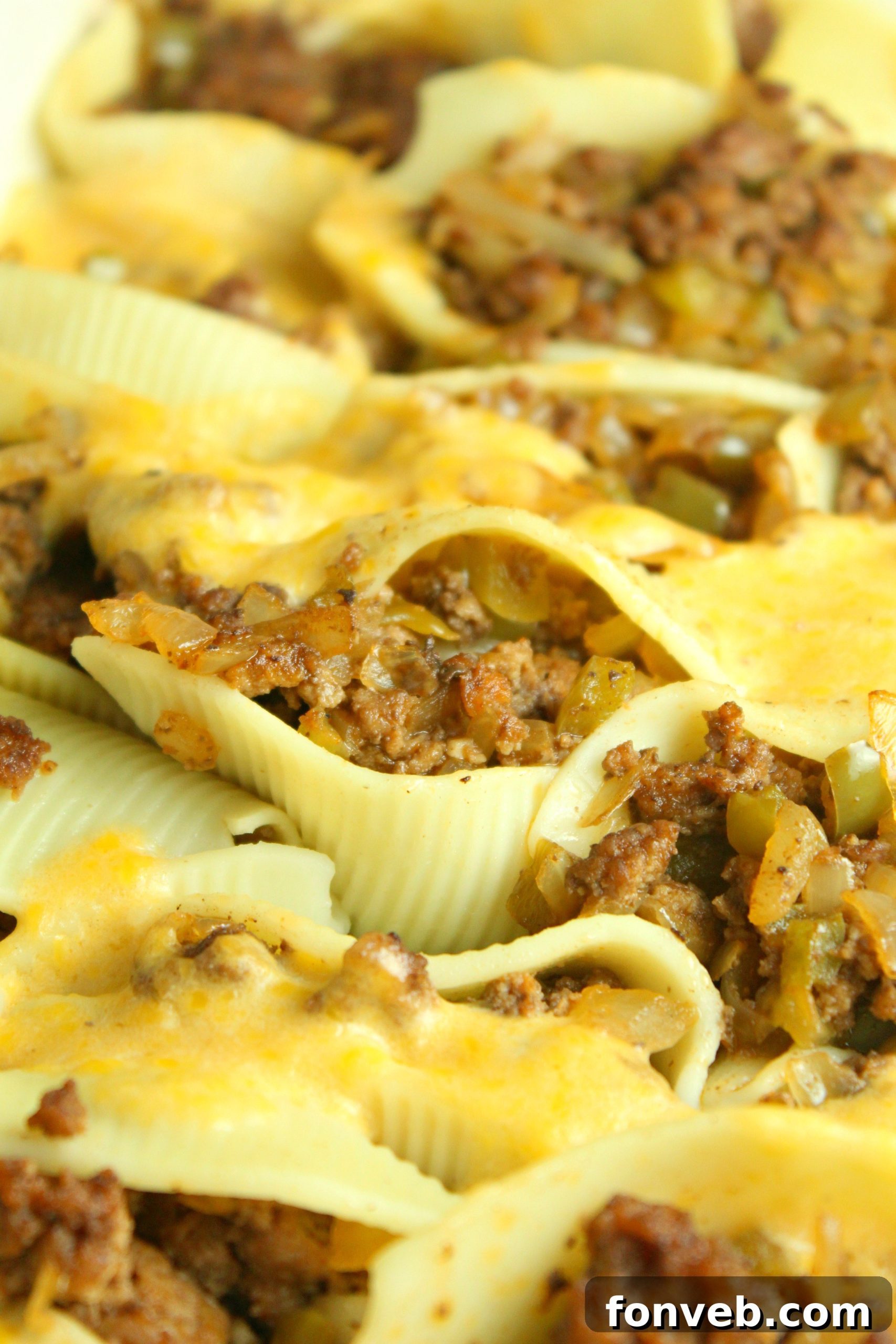 A large pan filled with a generous amount of baked Philly Cheese Steak Stuffed Shells, ready to be served.