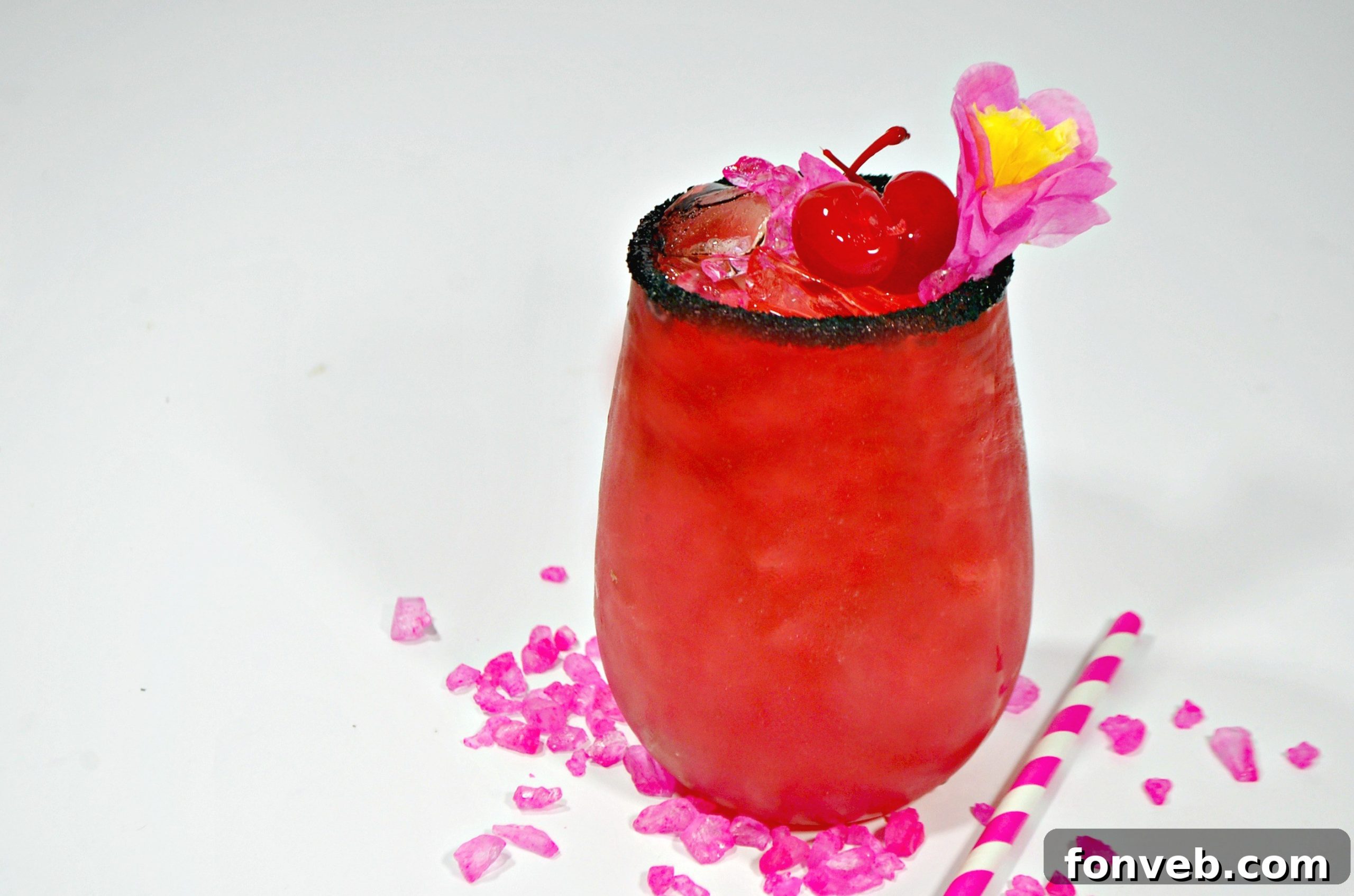 Two vibrant pink Barbie cocktails, garnished with lime, cherries, and black sprinkles, set against a dark background.