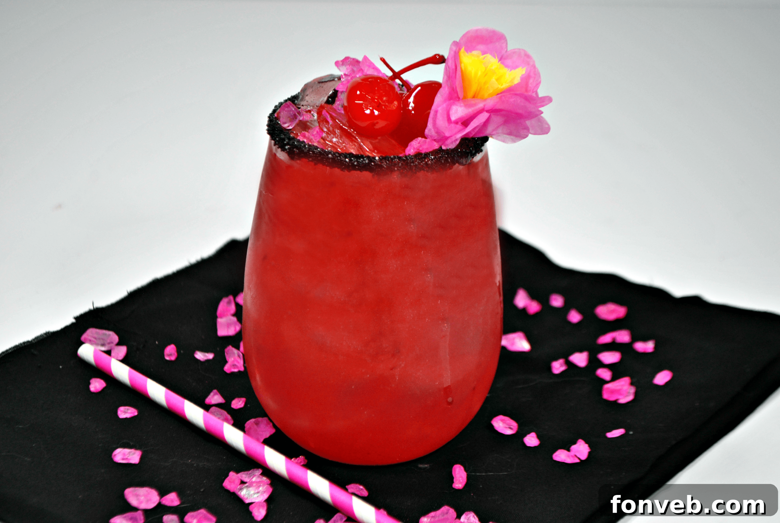 A close-up of a single Bad Ass Barbie Cocktail with a dark, sparkly rim and vibrant pink liquid, showcasing its elegant presentation.