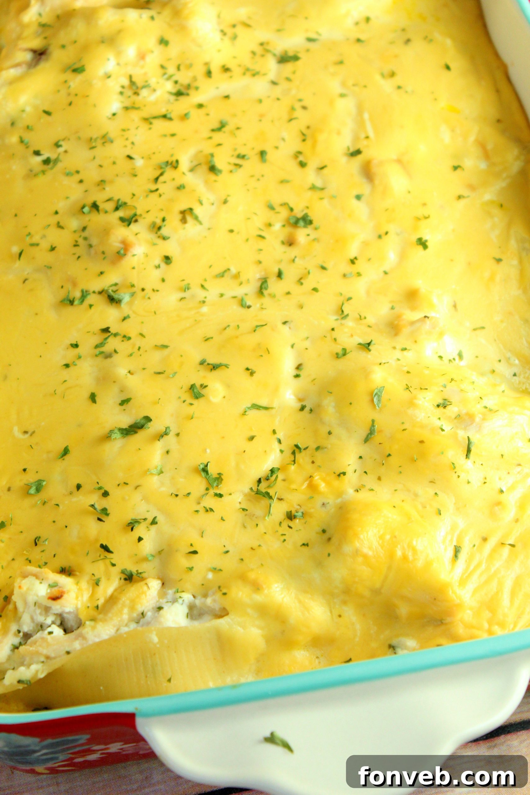 Creamy Garlic Chicken Stuffed Pasta Bake 2 Beautifully baked cheesy garlic chicken stuffed shells in a white casserole dish, garnished with fresh parsley.