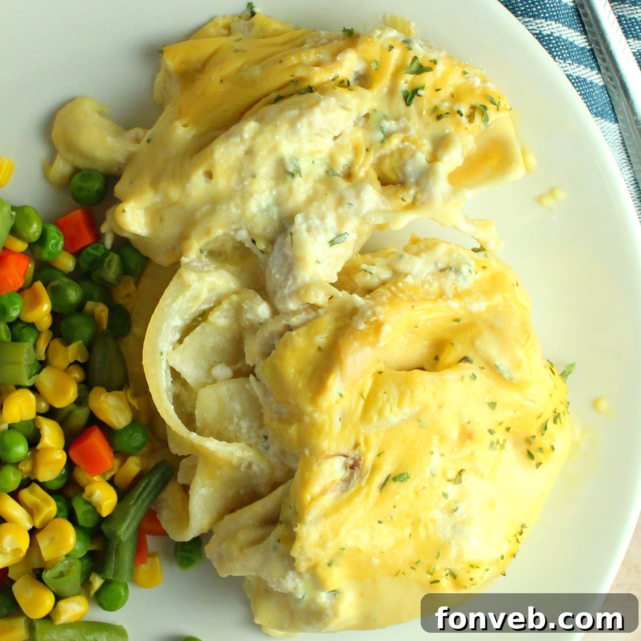 Creamy Garlic Chicken Stuffed Pasta Bake 5 A serving of cheesy garlic chicken stuffed shells on a plate, garnished with fresh herbs.