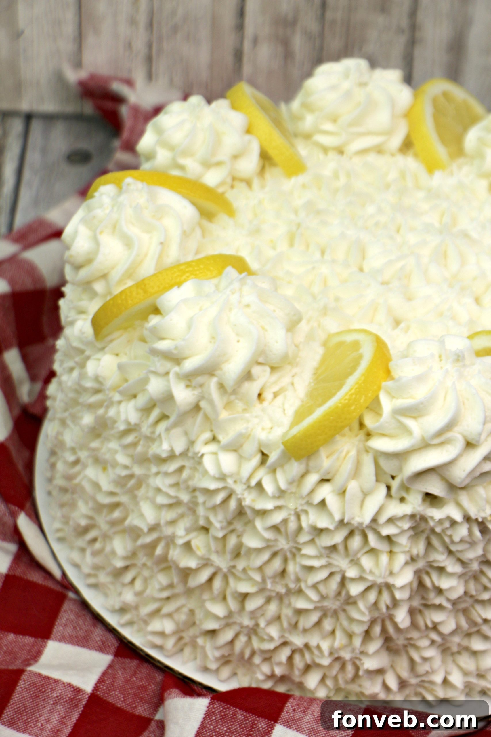 Close-up of a slice of Italian Lemon Drop Cake revealing its moist layers and creamy frosting.