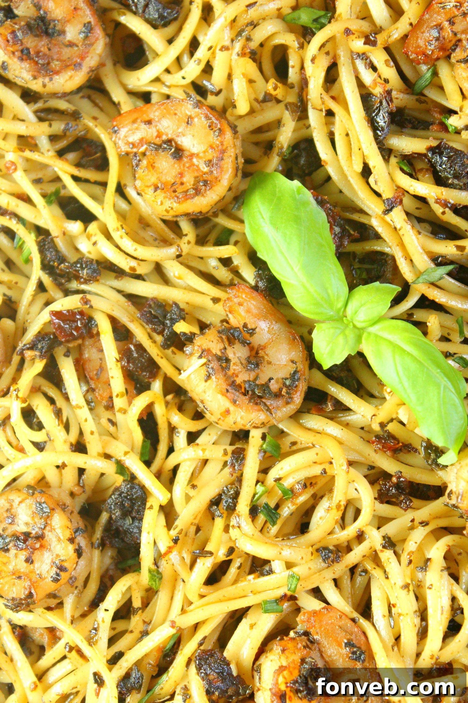 Sun-Dried Tomato Garlic Shrimp Pasta garnished with fresh herbs