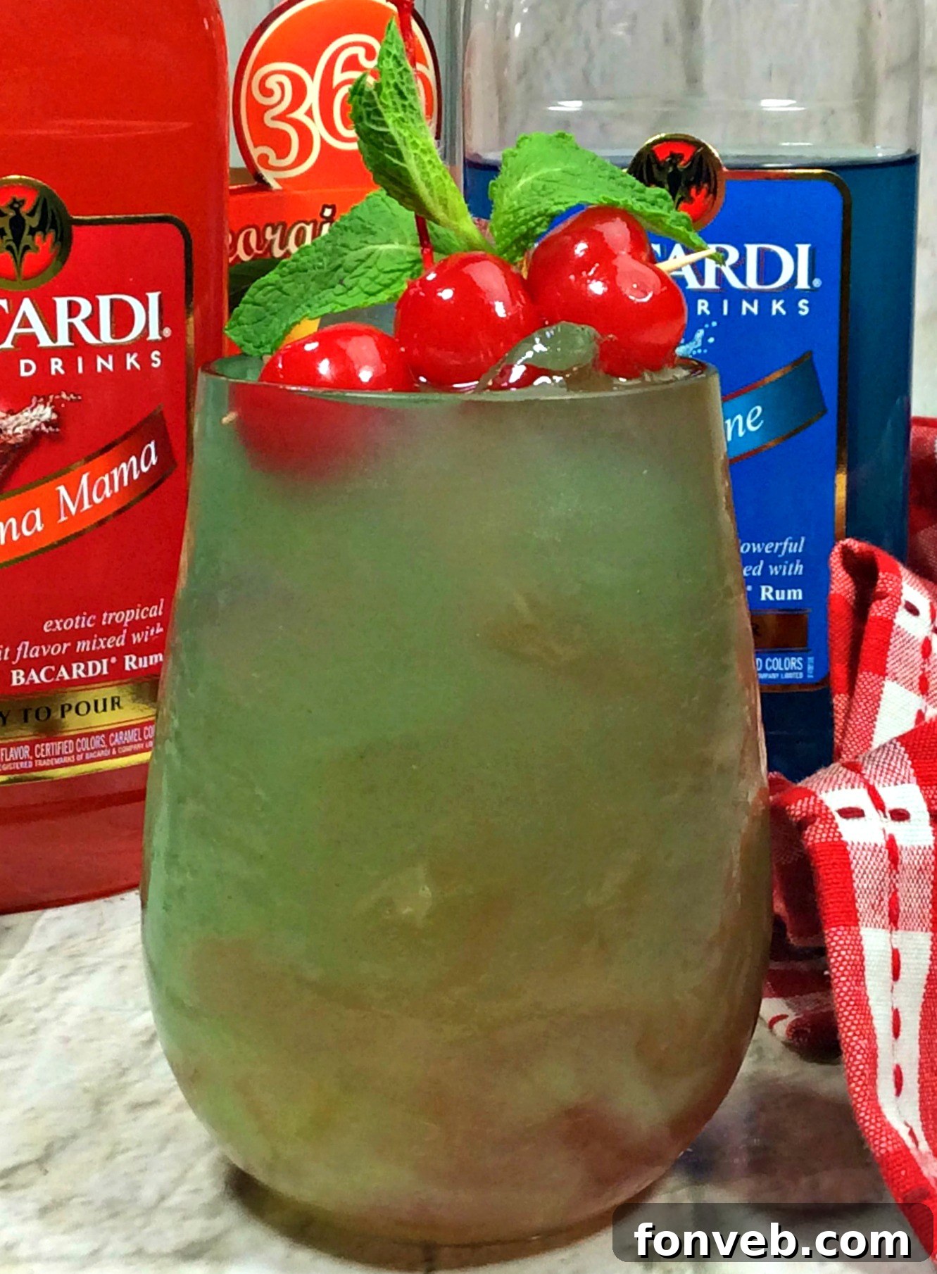 Vibrant green Sex on the Grass Cocktail with ice and a cherry garnish, ready to be enjoyed.