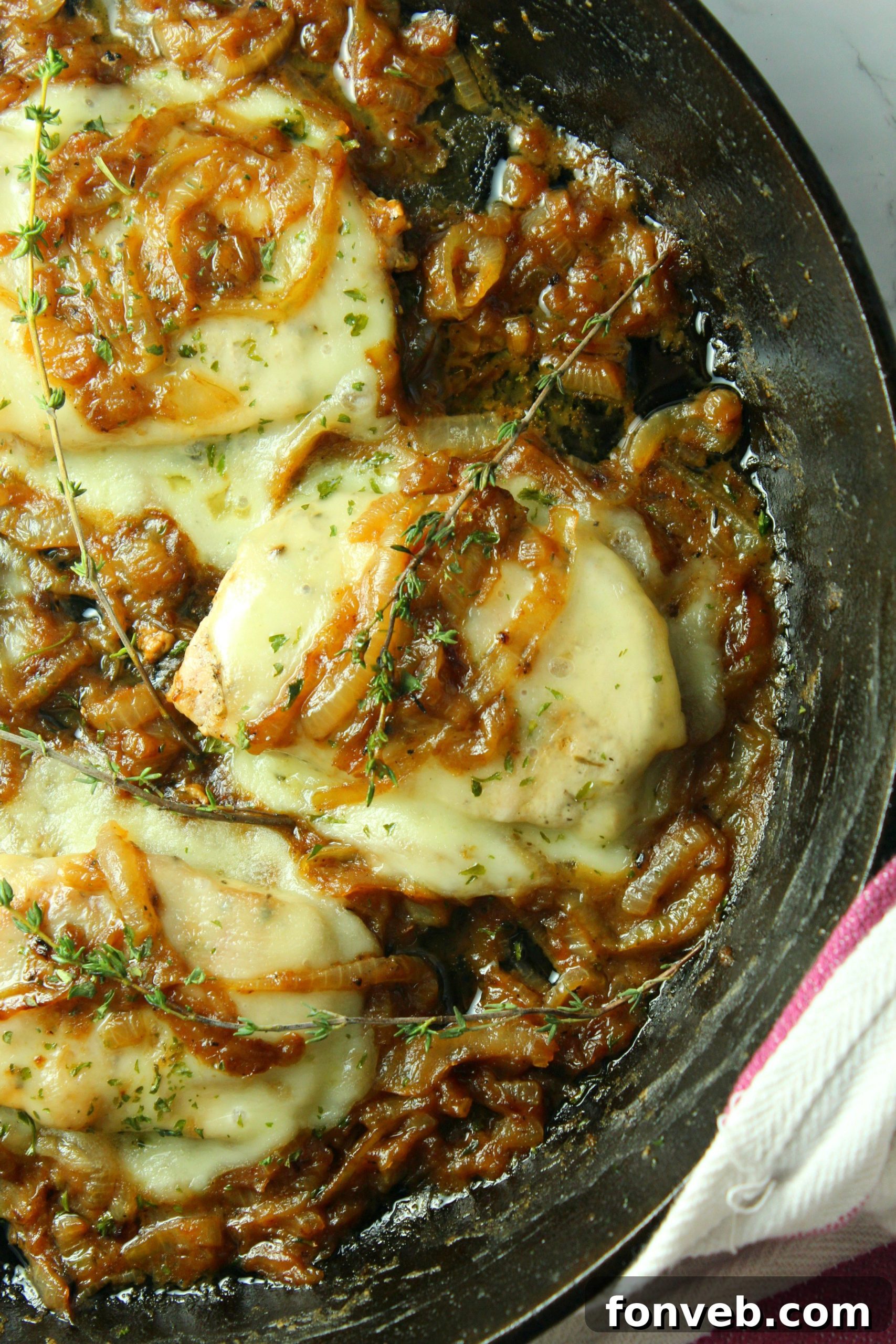 Golden-brown seared pork chops generously smothered with a rich layer of caramelized French onions and melted cheese, ready to be served