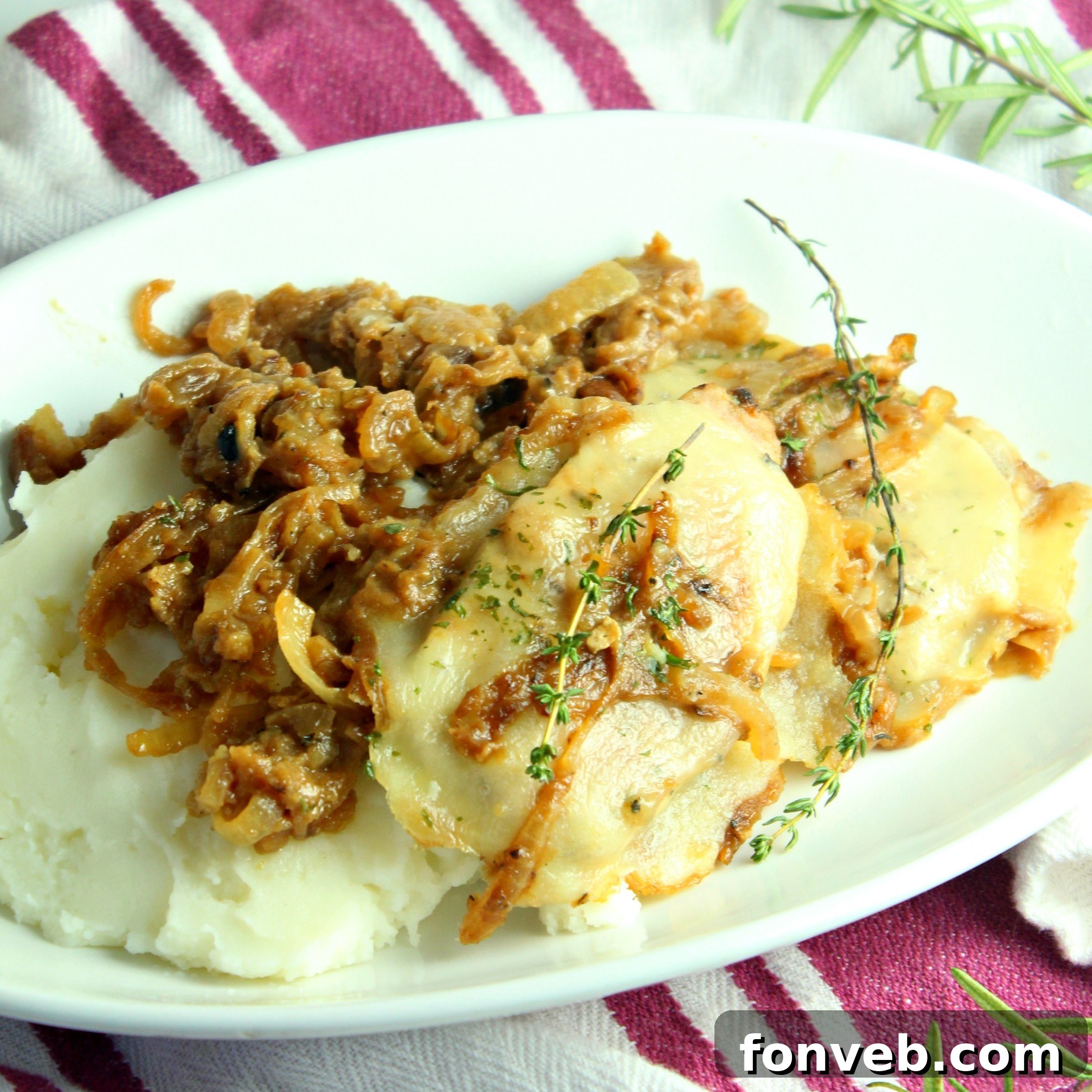Cooked smothered French onion pork chops presented beautifully in a large oven-safe skillet, garnished with fresh herbs