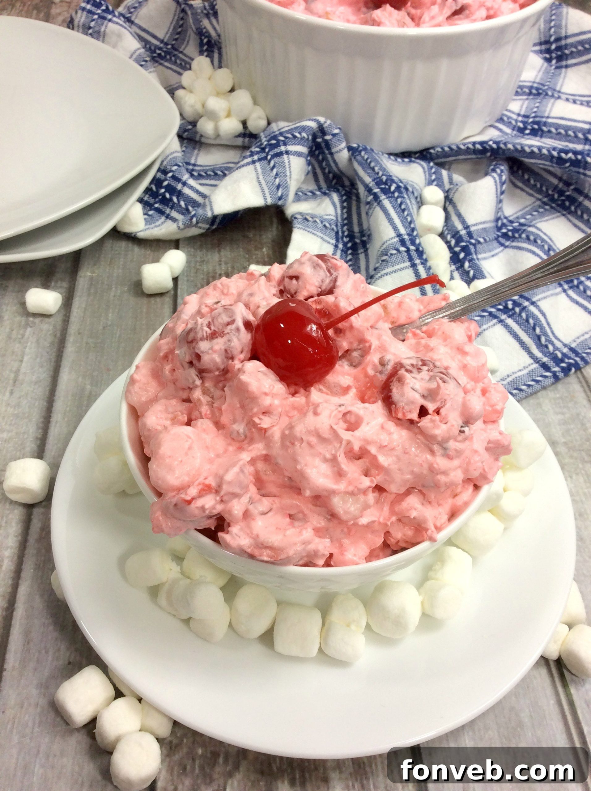 Cloud Nine Cherry Delight 2 Cherry Fluff Salad served in a glass bowl, garnished with whole maraschino cherries and mint leaves.