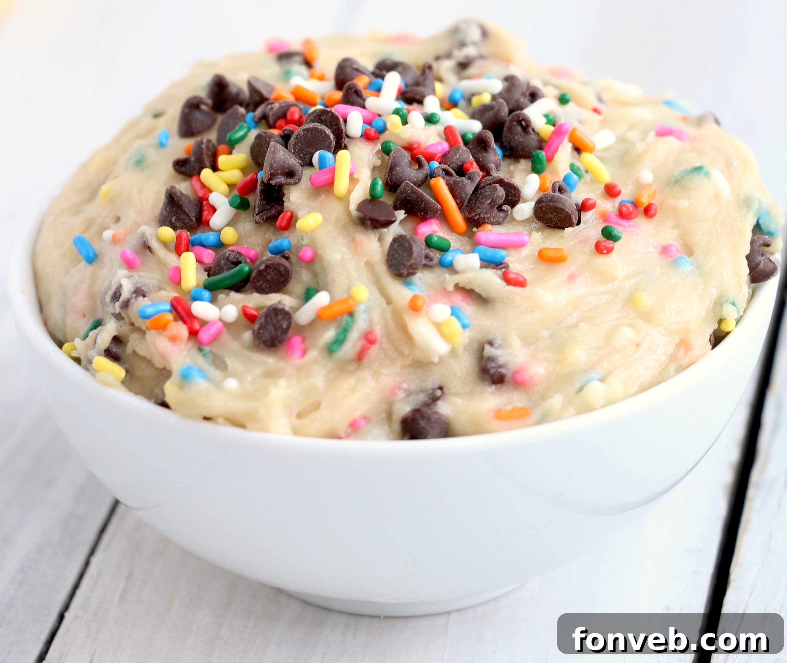 A generous serving of Funfetti Cookie Dough Dip in a bowl, with various sweet and savory dippers arranged around it.