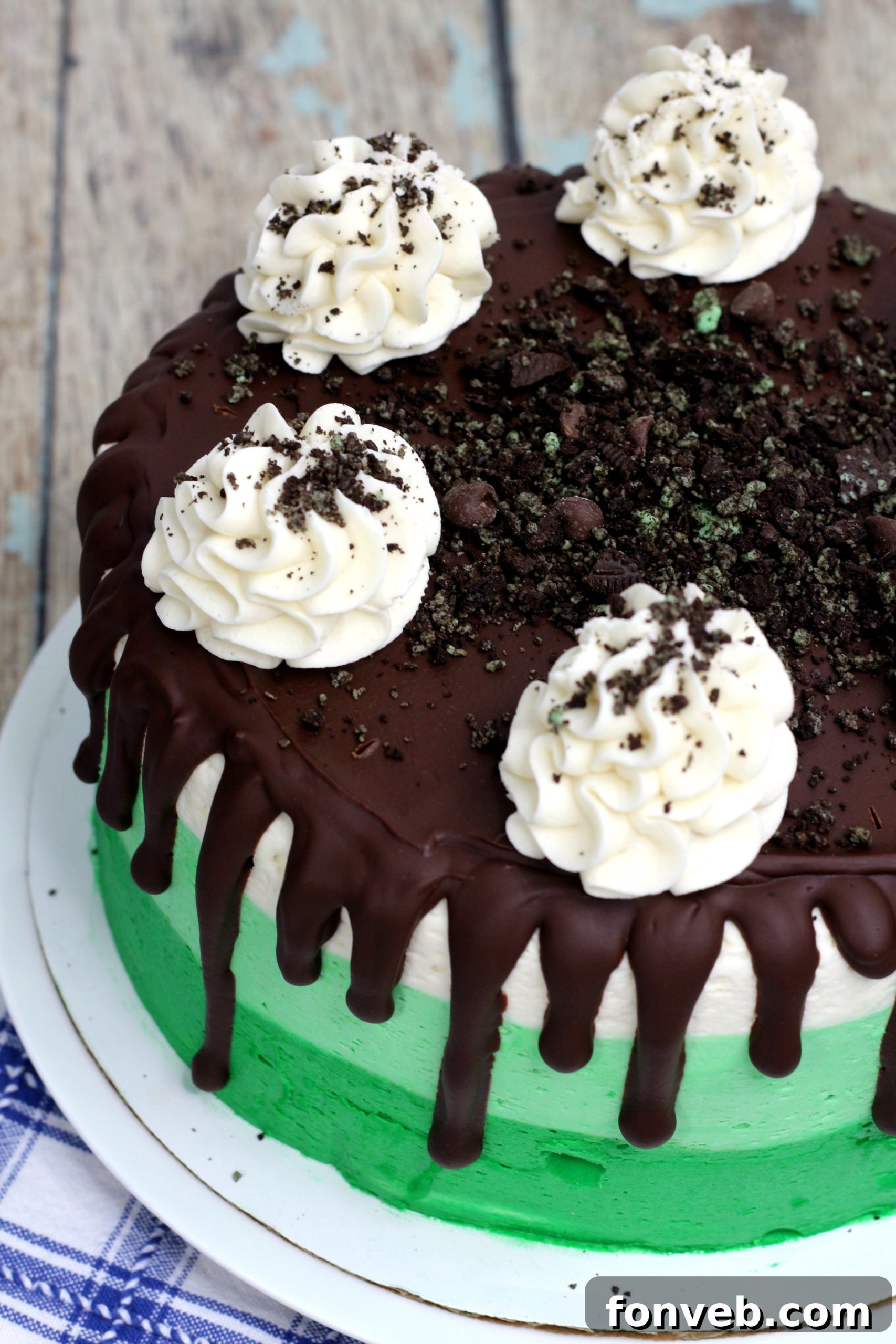 Cool Mint Oreo Decadence 8 A perfectly cut slice of Mint Oreo Layered Cake, showcasing the beautiful green layers, white and green frosting, and chocolate drizzle.