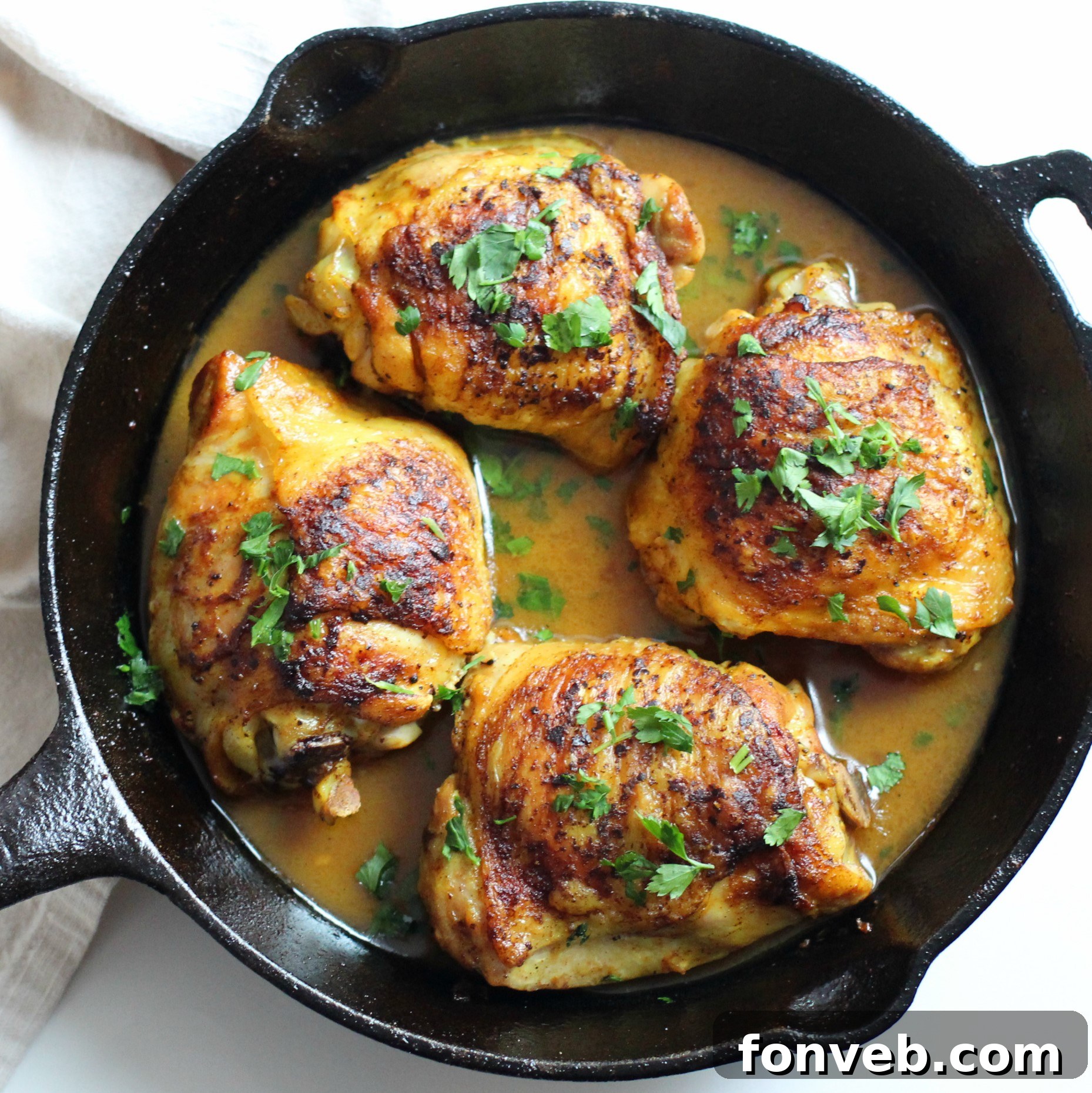 A serving of brown sugar lemon chicken on a plate, garnished with fresh parsley, next to a bowl of rice or mashed potatoes.
