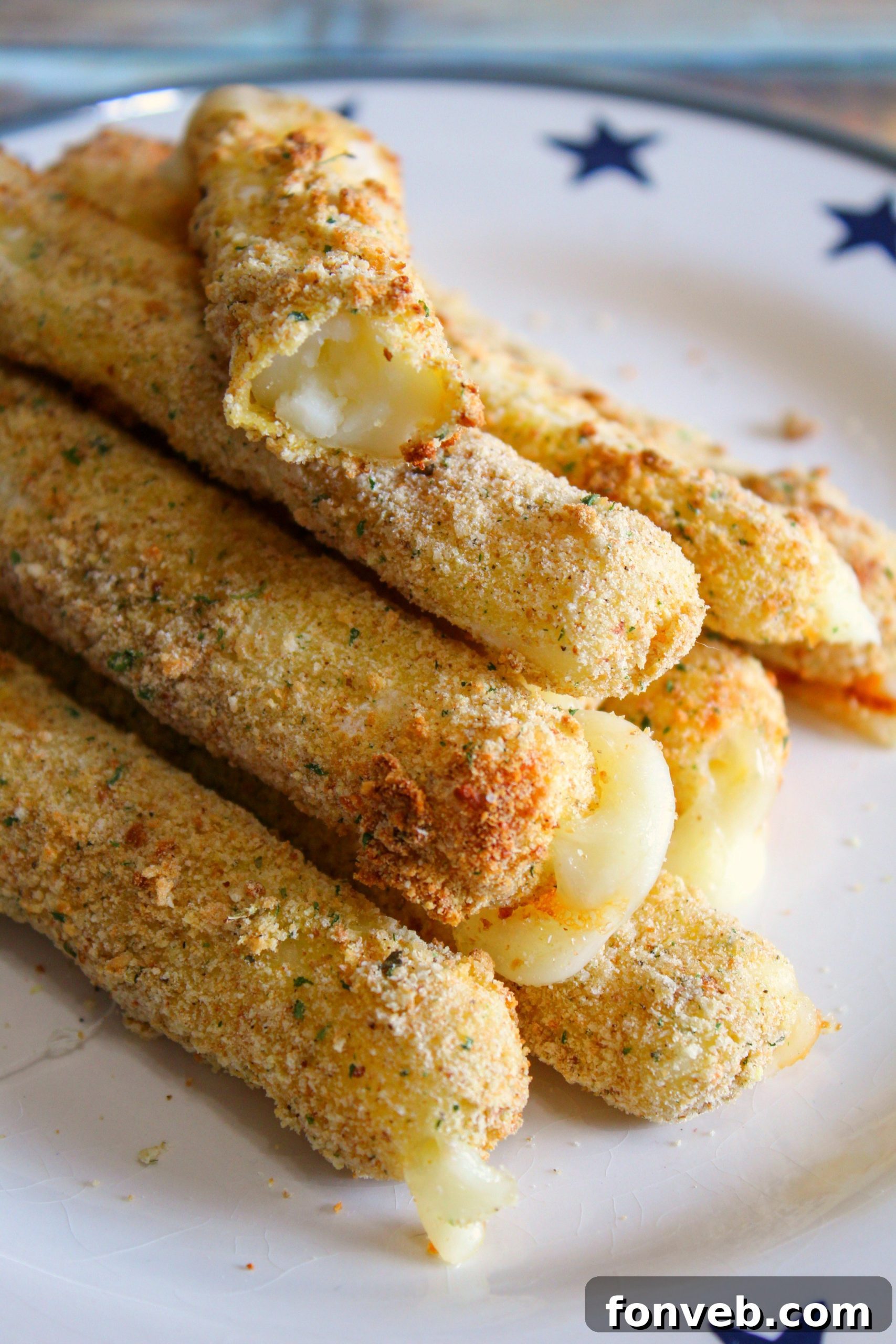 Golden brown and perfectly melted Air Fryer Mozzarella Sticks on a serving platter, ready to be enjoyed.