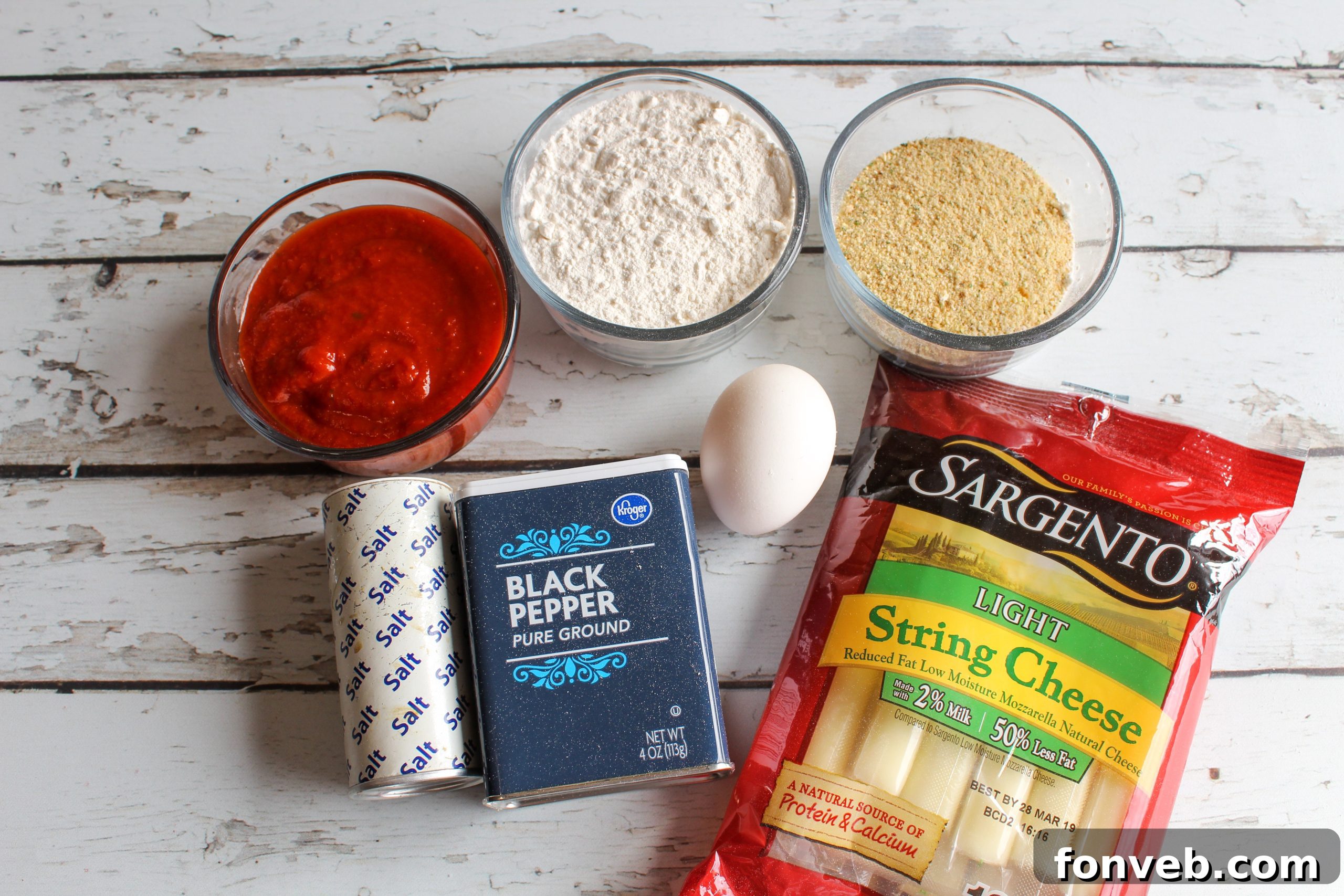Close-up of a hand pulling apart an Air Fryer Mozzarella Stick, showcasing the long, stretchy melted cheese.