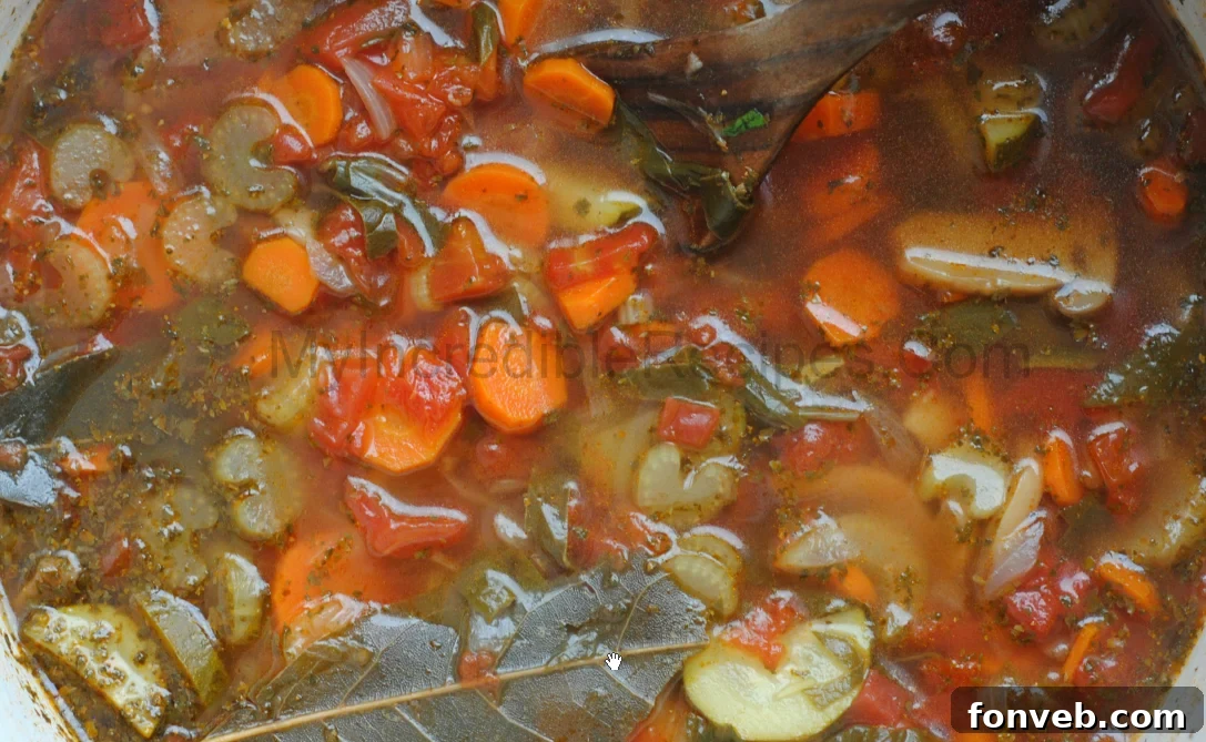 up close shot of Weight loss soup in a red dutch oven pot on a dark wood table 