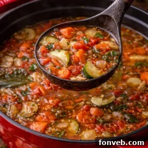 Weight Loss Soup in a red dutch oven with a spoon lifting up some