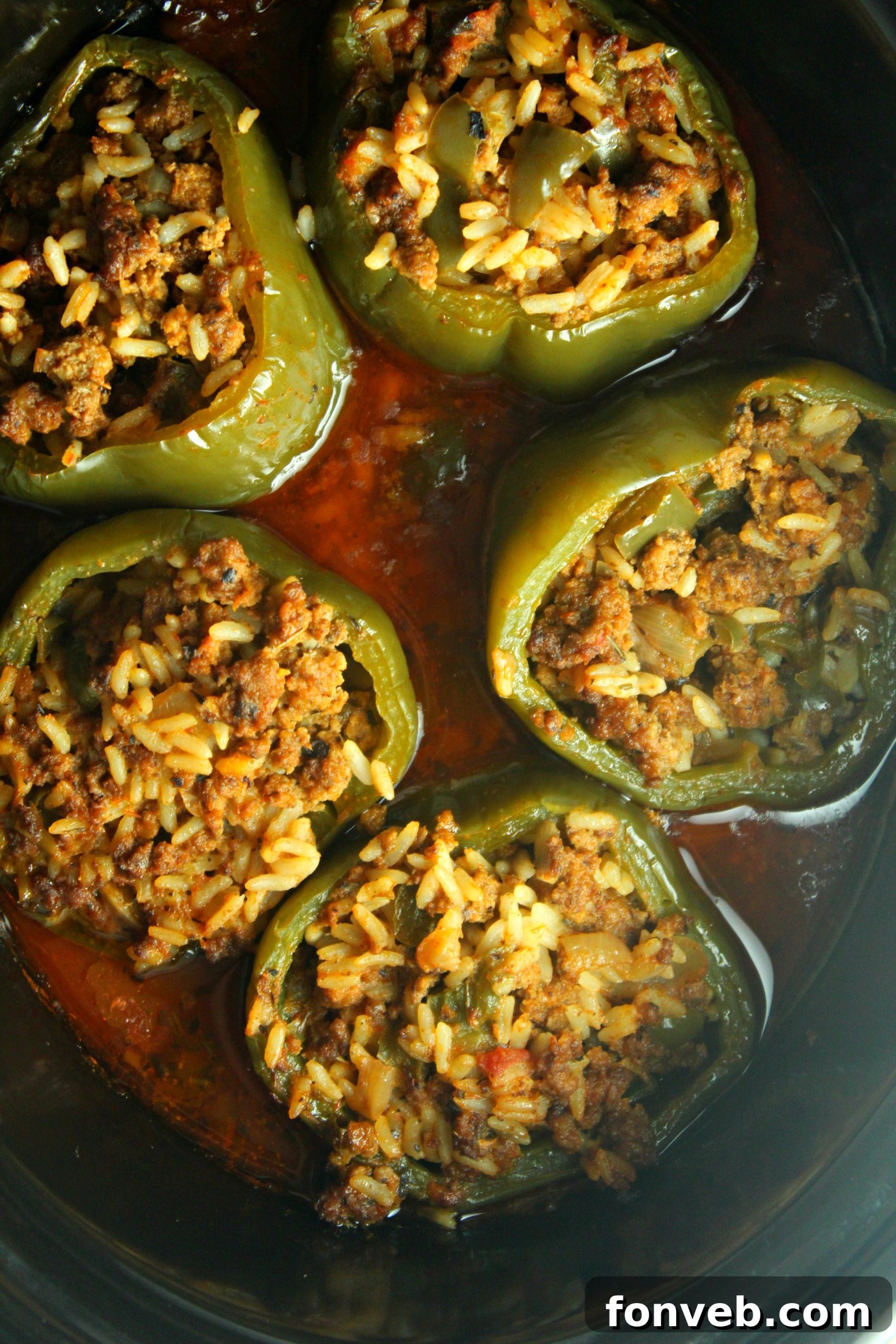 A top-down view of Slow Cooker Stuffed Peppers simmering in a crock pot, showcasing the delicious filling and bubbling sauce.