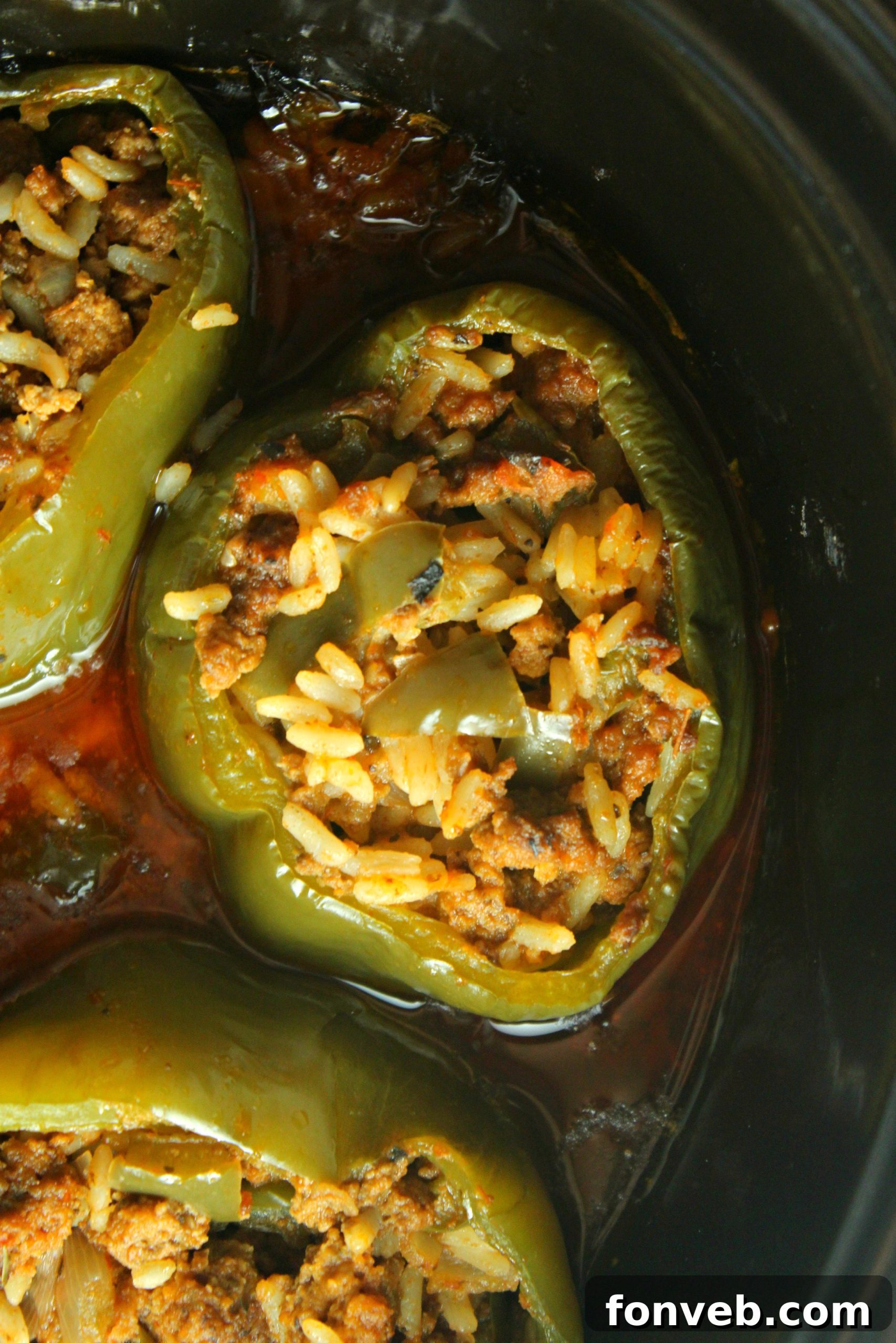 A close-up of a single Slow Cooker Stuffed Pepper on a serving plate, highlighting the perfectly cooked pepper and the texture of the beef and rice filling.
