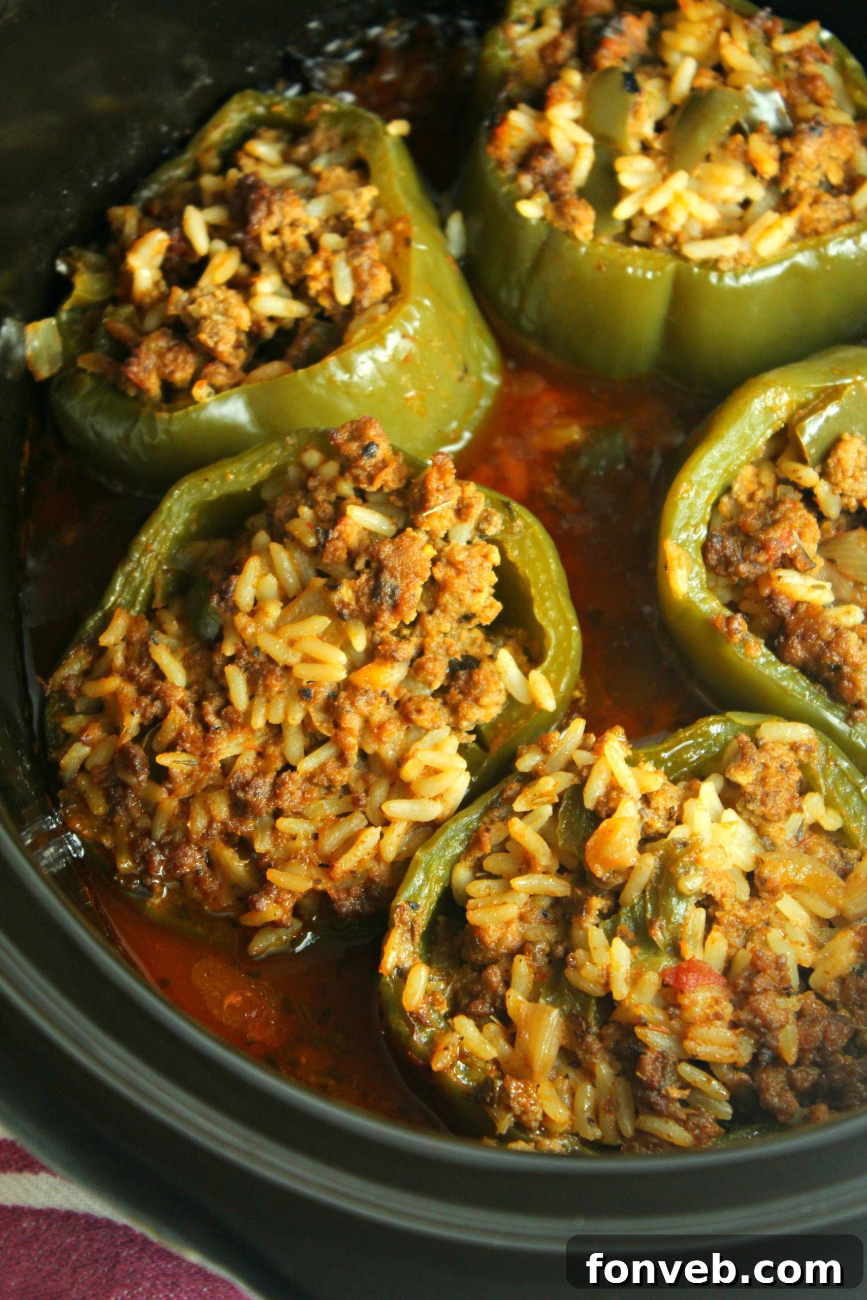 A stack of uncooked green bell peppers, ready to be prepared for stuffing, symbolizing the fresh ingredients.