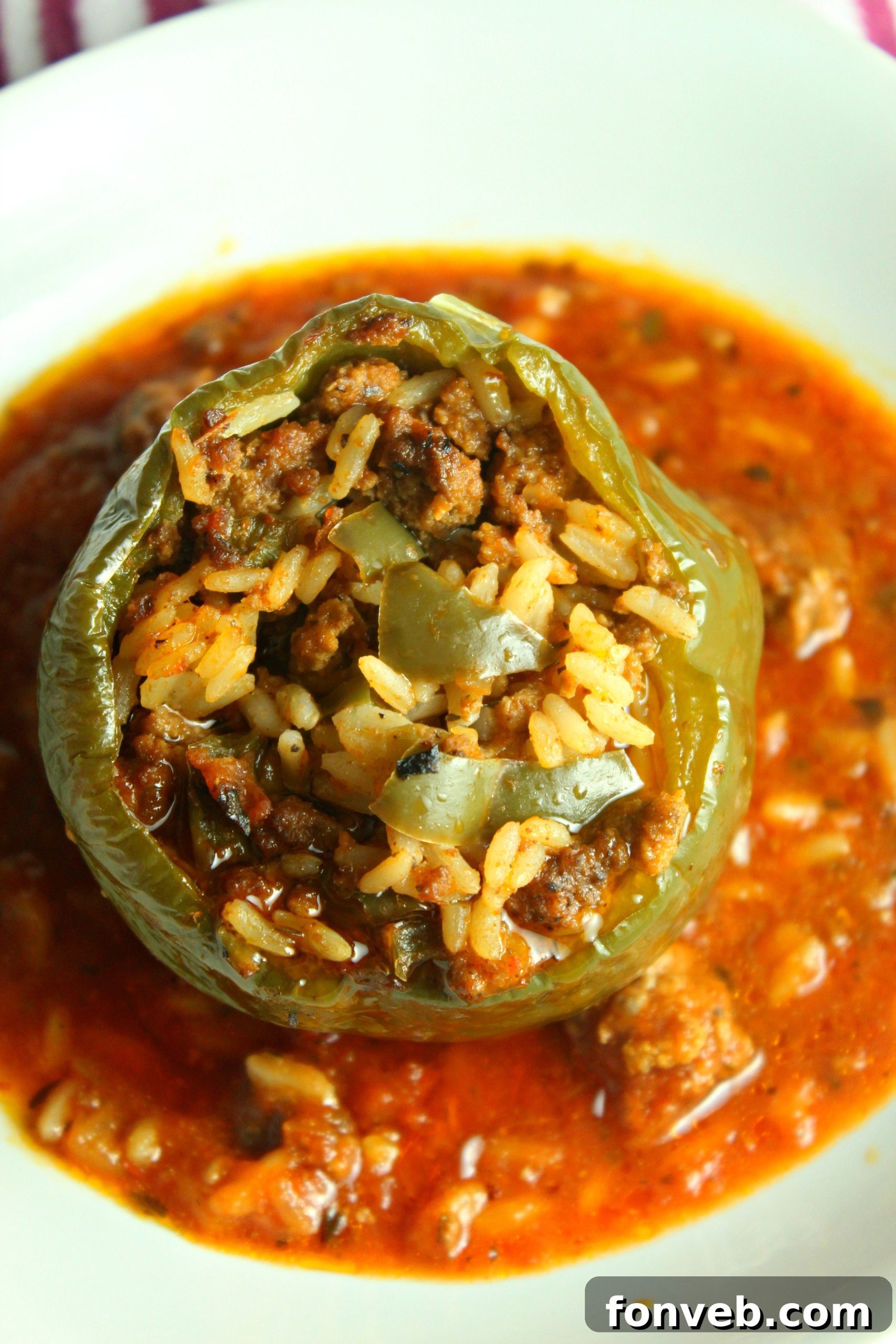 A full slow cooker filled with Slow Cooker Stuffed Peppers, bubbling with tomato sauce and ready to be served.