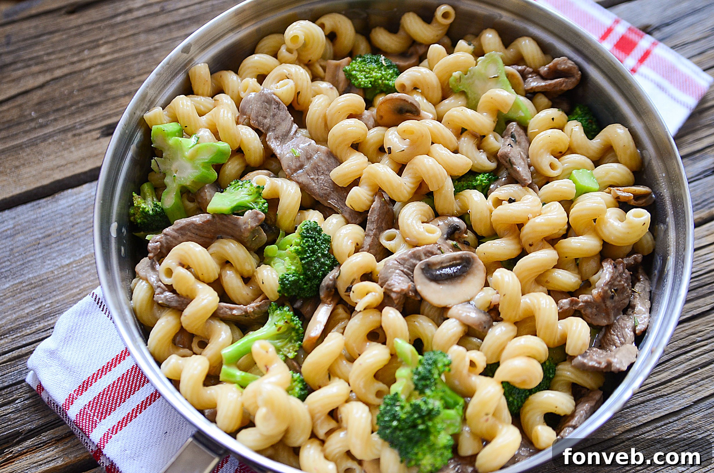 Hearty Beef, Mushroom & Broccoli Pasta 8 An overhead shot of a single serving of Beef, Mushroom, and Broccoli Pasta with a fork, ready to eat.