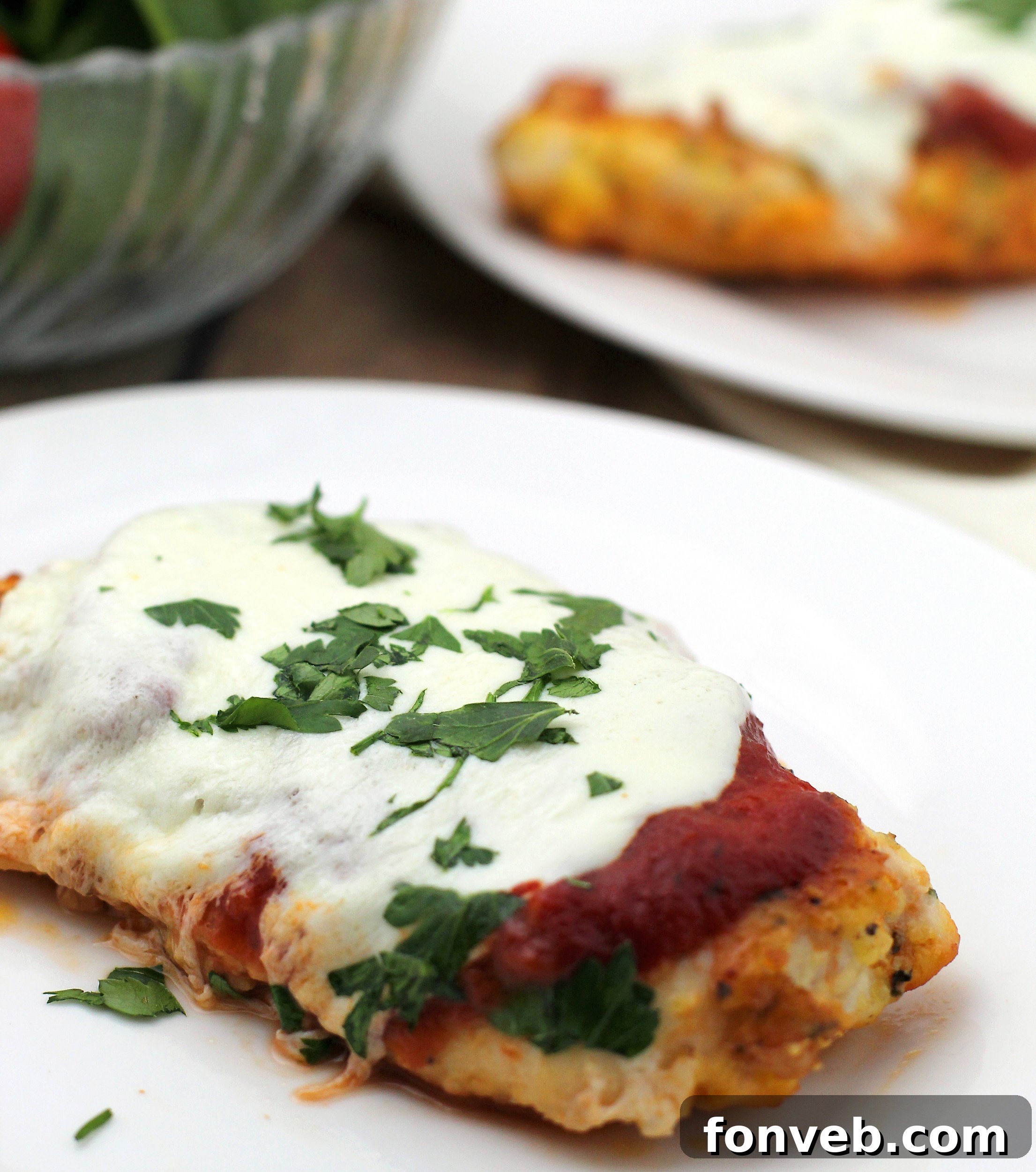 A serving of Keto Chicken Parmesan with fresh herbs.