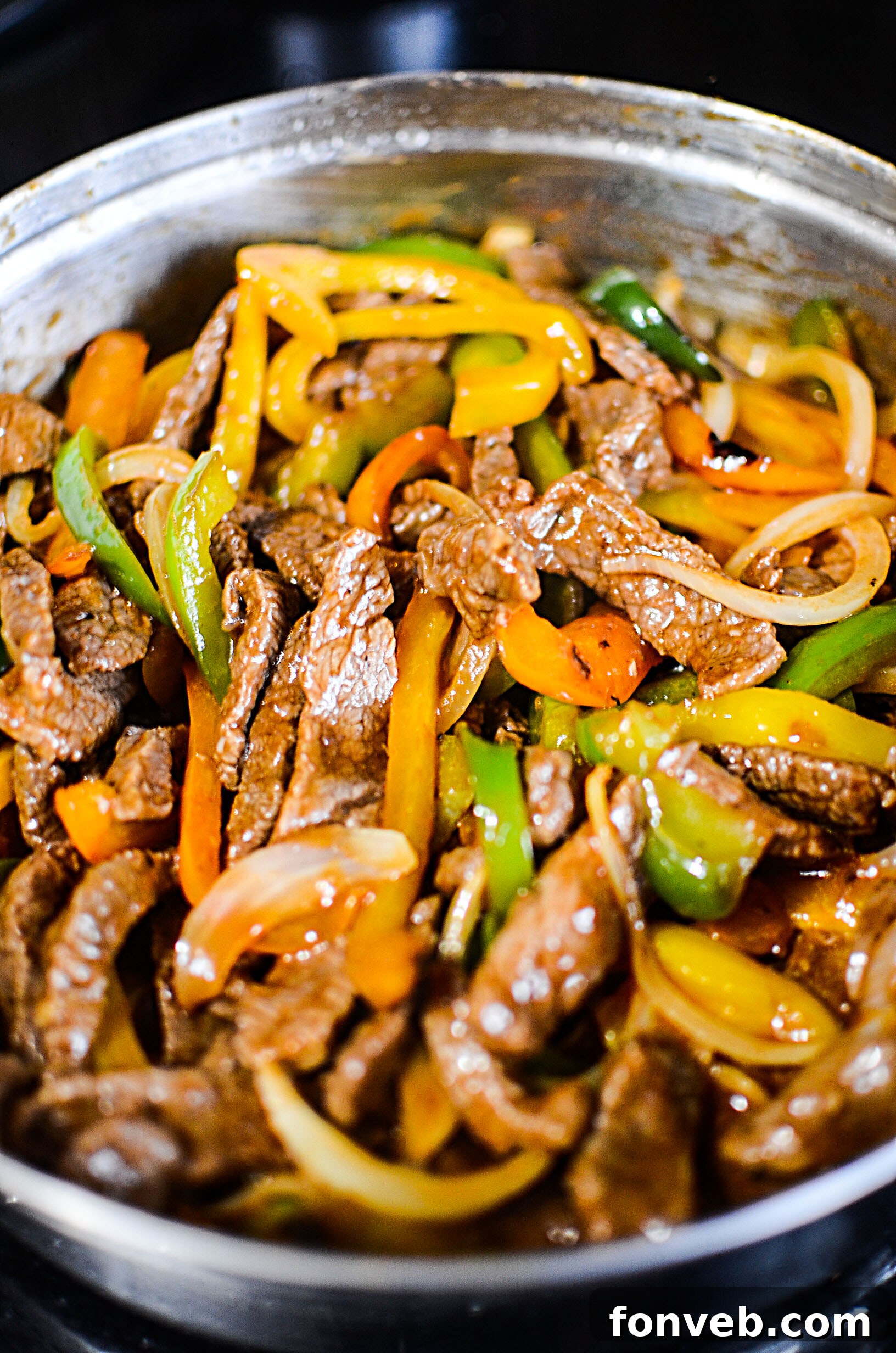 Overhead shot of the Low Carb Philly Cheesesteak Skillet with steak, onions, peppers, and melted cheese, garnished with fresh parsley.