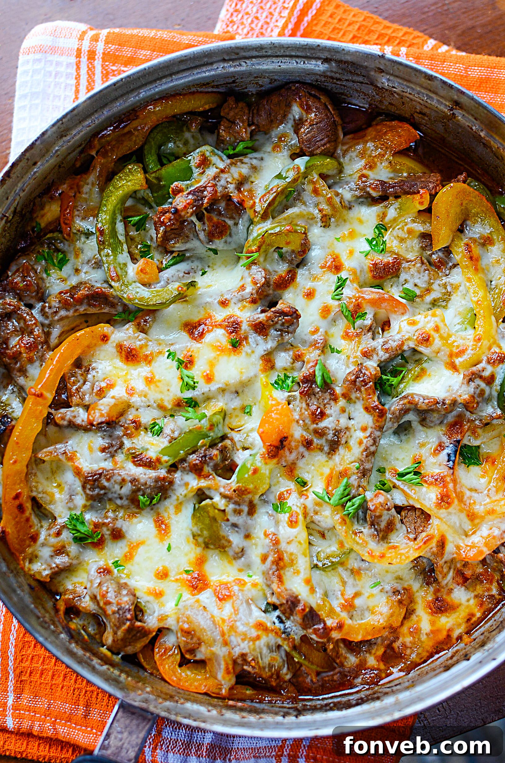 A close-up of the delicious ingredients in the Philly Cheesesteak Skillet, showing the texture of the steak and the vibrant colors of the bell peppers.