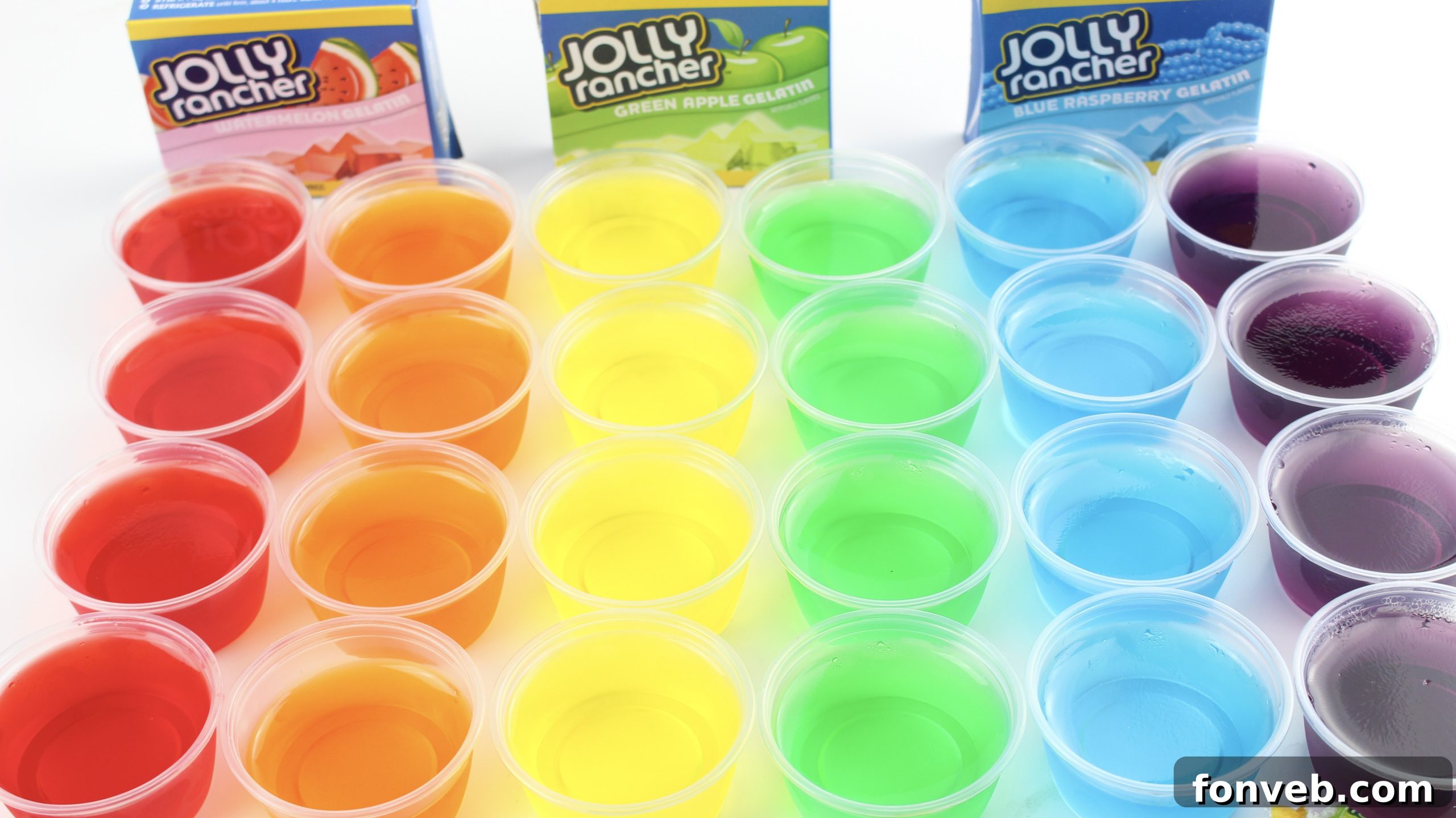 Six different colored Jello shots arranged on a table, showcasing the colorful variety.