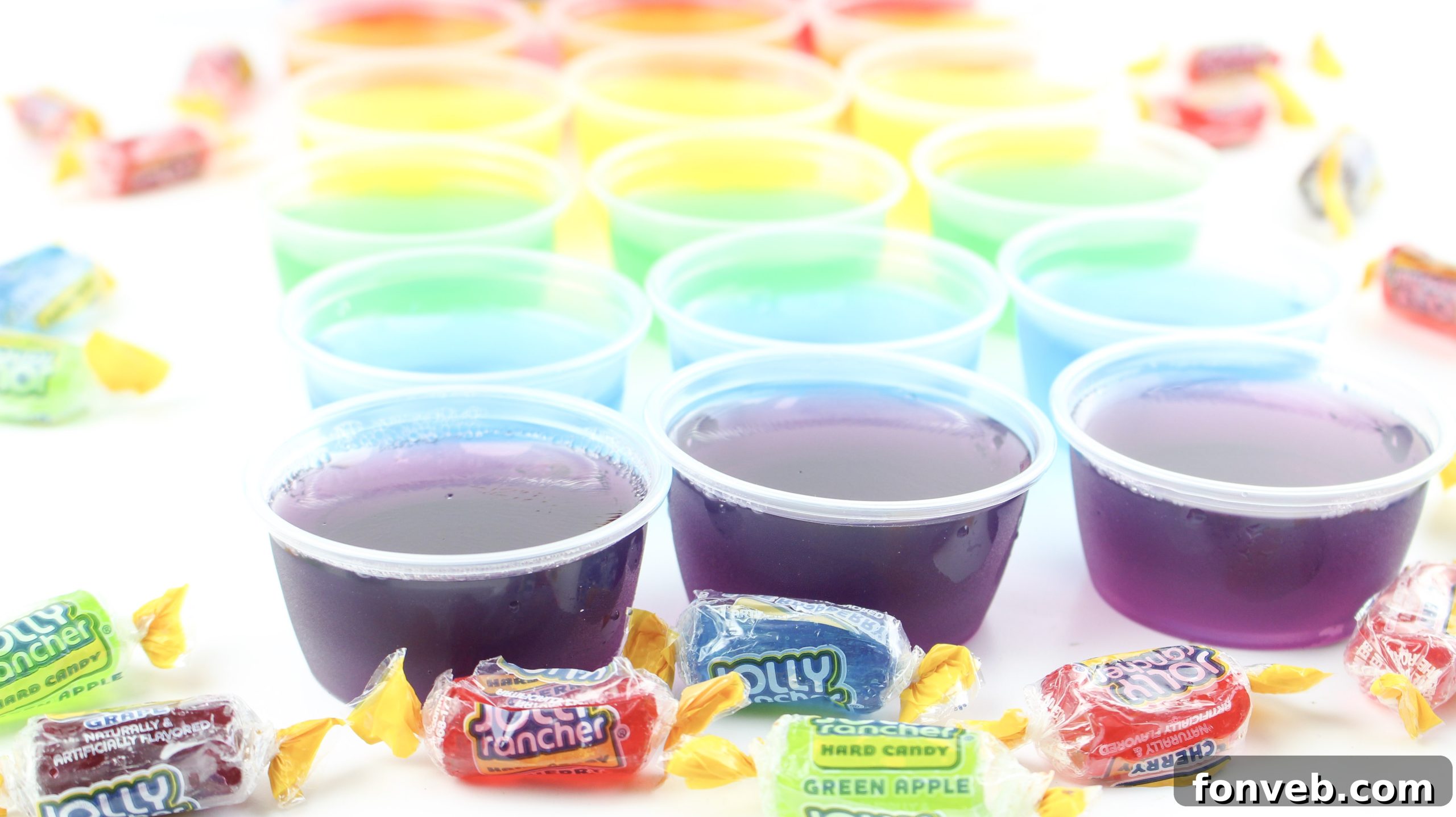 A variety of colorful Jello shots, including purple, red, and yellow, arranged appealingly for a party.