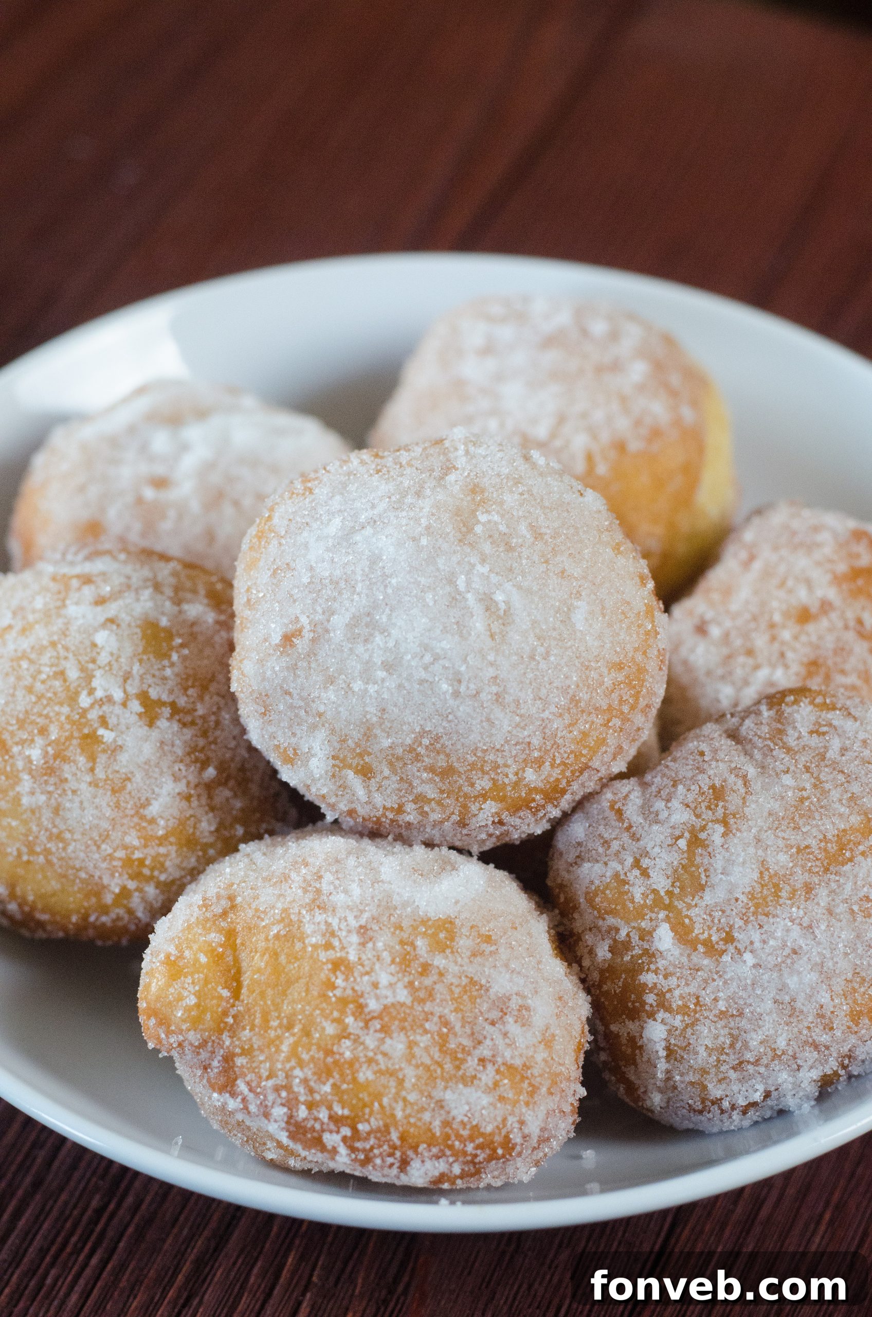 Chinese Fried Doughnuts 7 Hand holding a freshly made Chinese sugar donut, showing its fluffy texture.