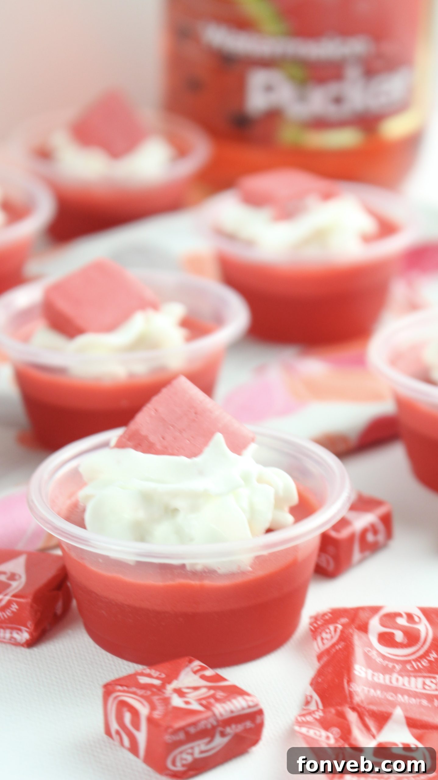 Individual Cherry Starburst Jell-O Shots with toppings, photographed from a high angle.