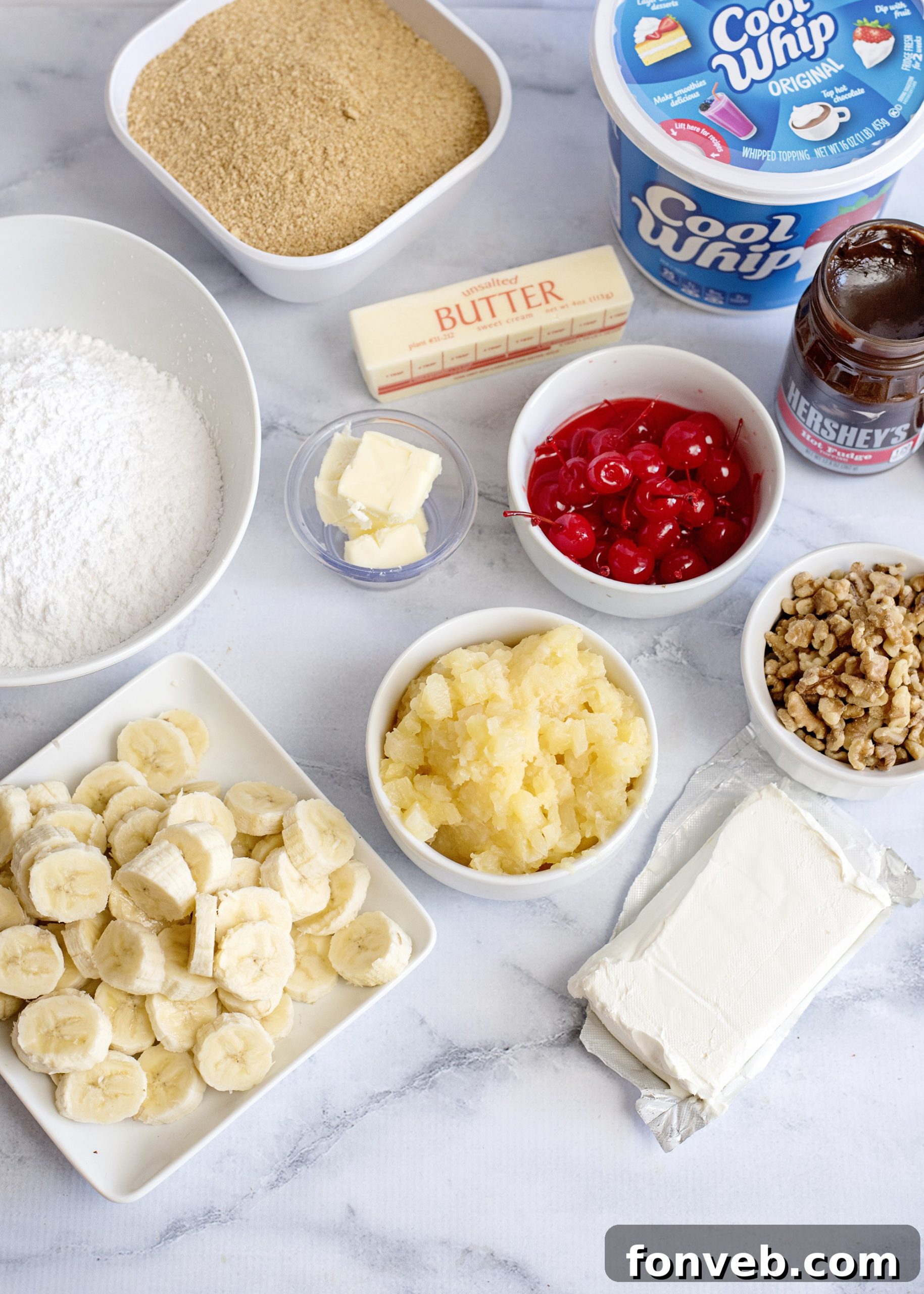 No Bake Banana Split Dream 3 A large rectangular dish filled with No-Bake Banana Split Dessert, topped with generous dollops of whipped cream, hot fudge, and maraschino cherries.