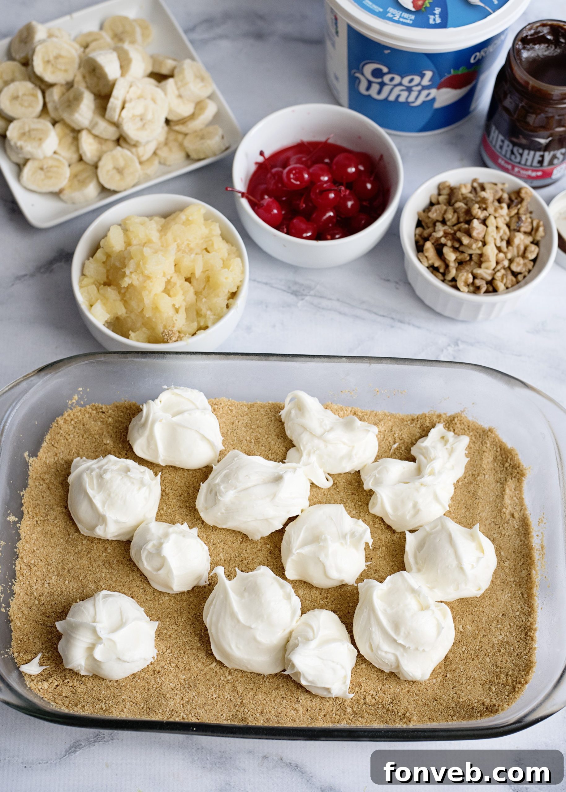 No Bake Banana Split Dream 4 A close-up view of the layered No-Bake Banana Split Dessert from an angle, highlighting the distinct layers of graham cracker crust, creamy filling, bananas, pineapple, and whipped topping.