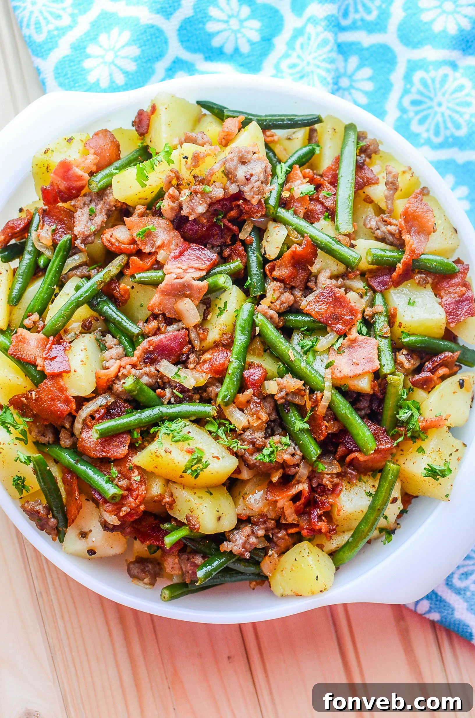 A hearty skillet of Southern Sausage, Potatoes, and Green Beans cooked with thick-cut bacon, ready to serve.
