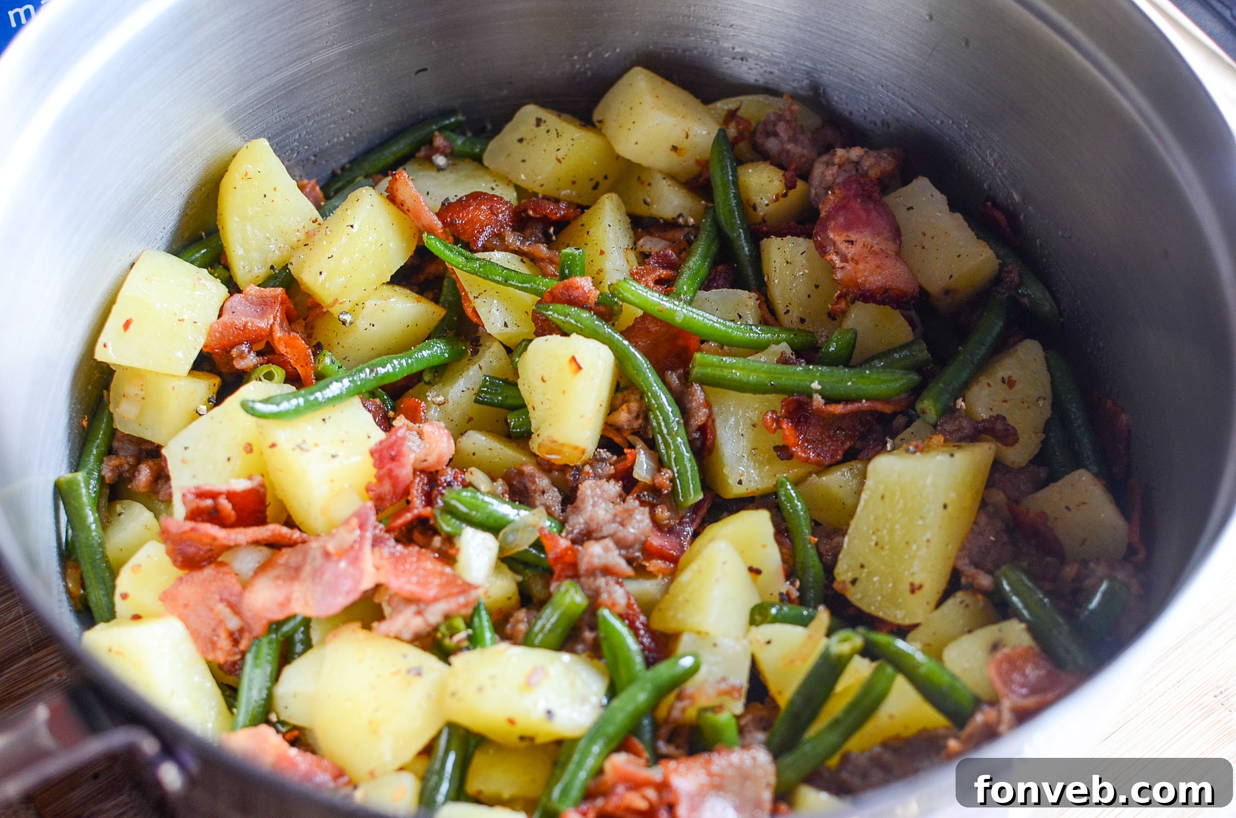 Overhead view of a cooked dish of Southern Sausage, Potatoes, and Green Beans, highlighting the fresh ingredients.