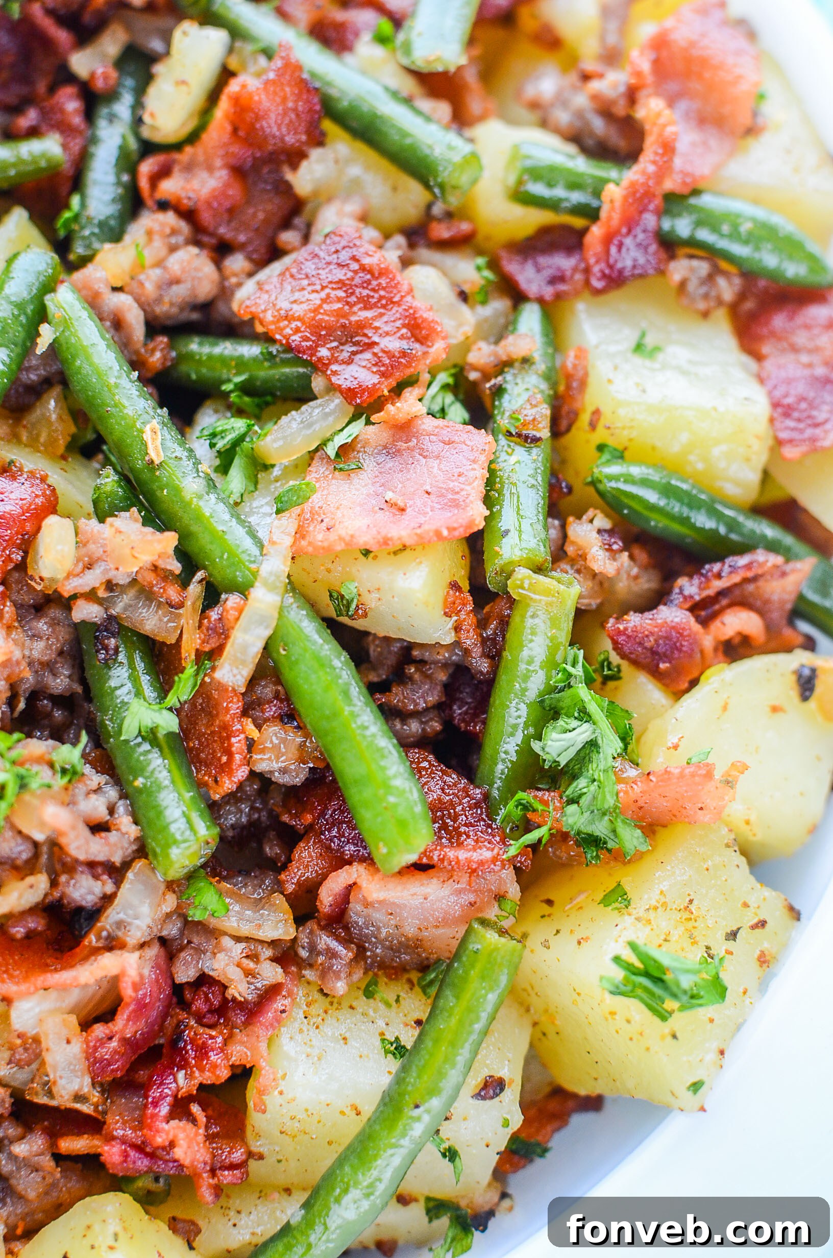 A serving of Southern Sausage, Potatoes, and Green Beans on a white plate, ready to be enjoyed.