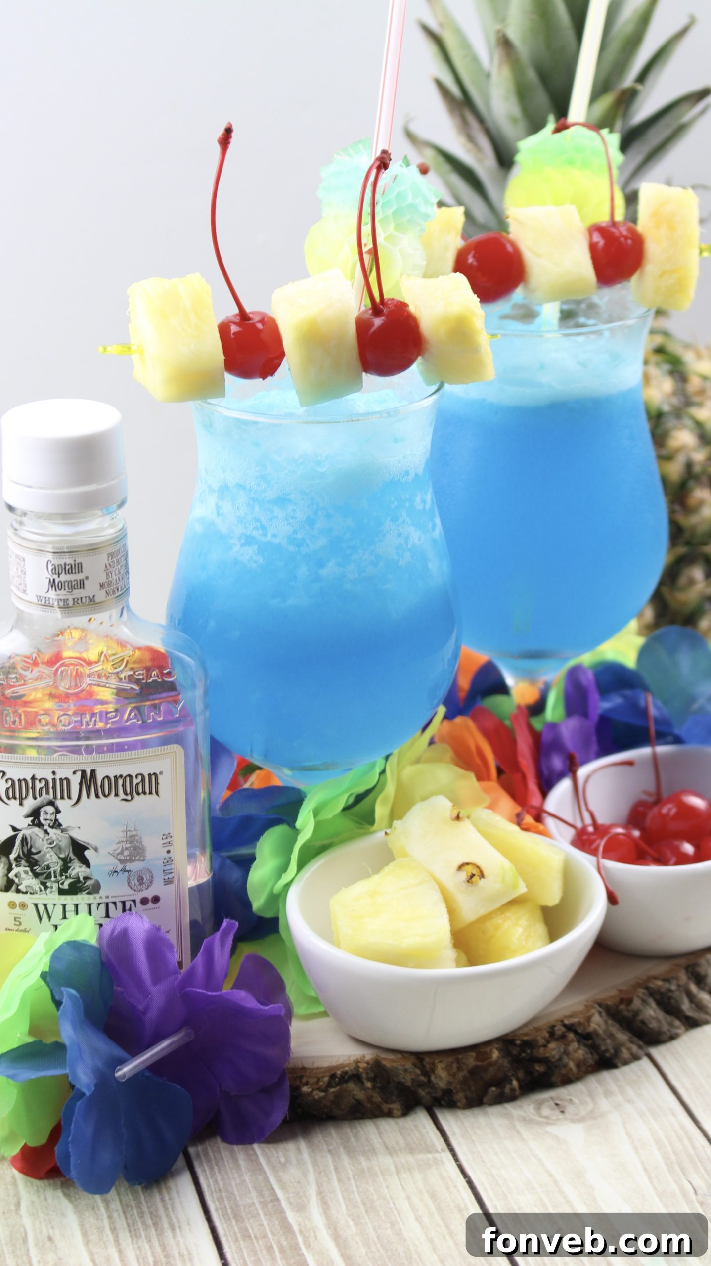 Blue Hawaiian Tropical Escape 2 Refreshing Blue Hawaiian cocktail in a hurricane glass, garnished with pineapple and a cherry.