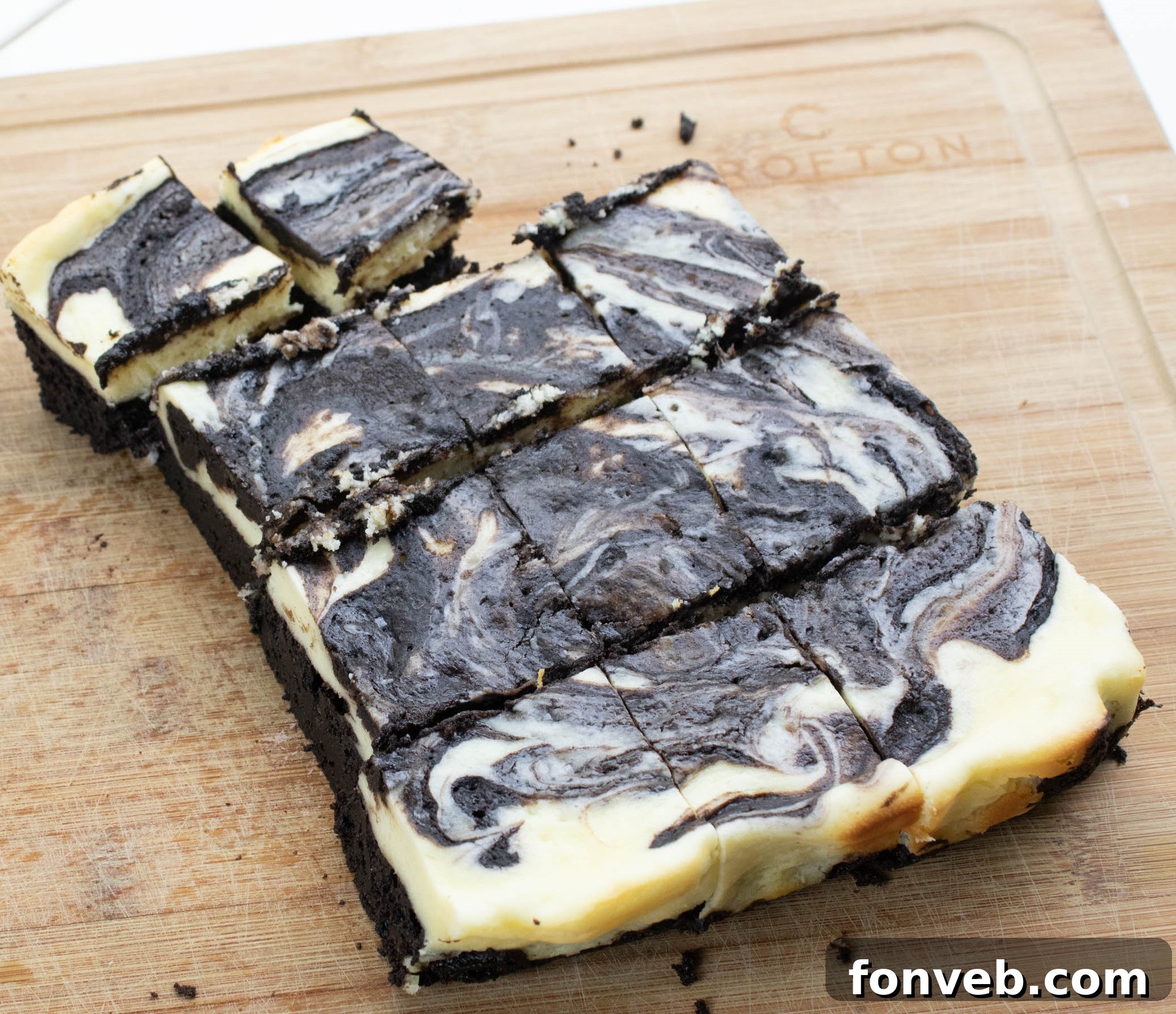 Close-up of a cut Cheesecake Swirl Brownie, revealing the rich chocolate and white cheesecake layers.