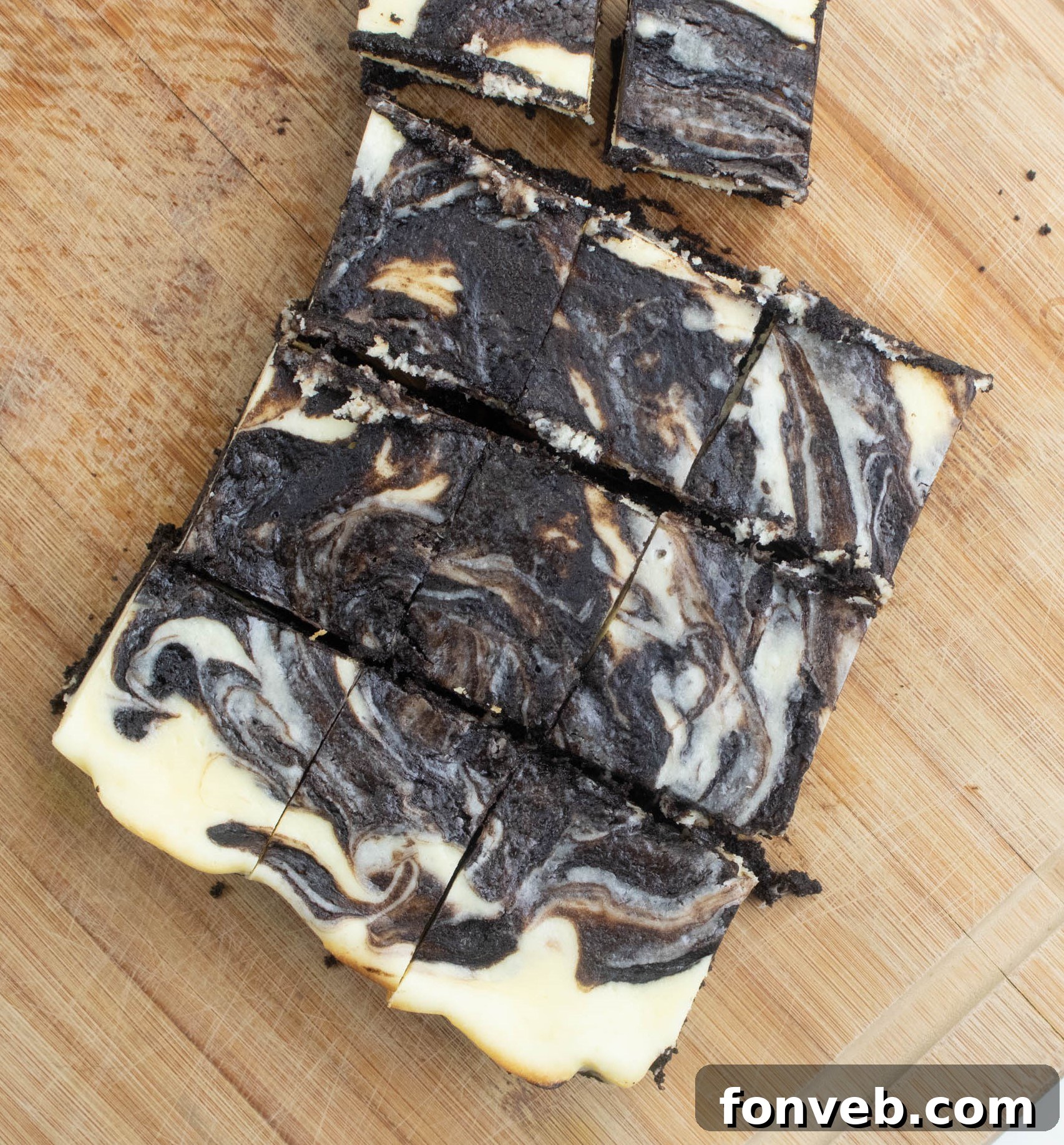 A batch of unbaked Cheesecake Swirl Brownies in a baking pan, showing the swirl process.