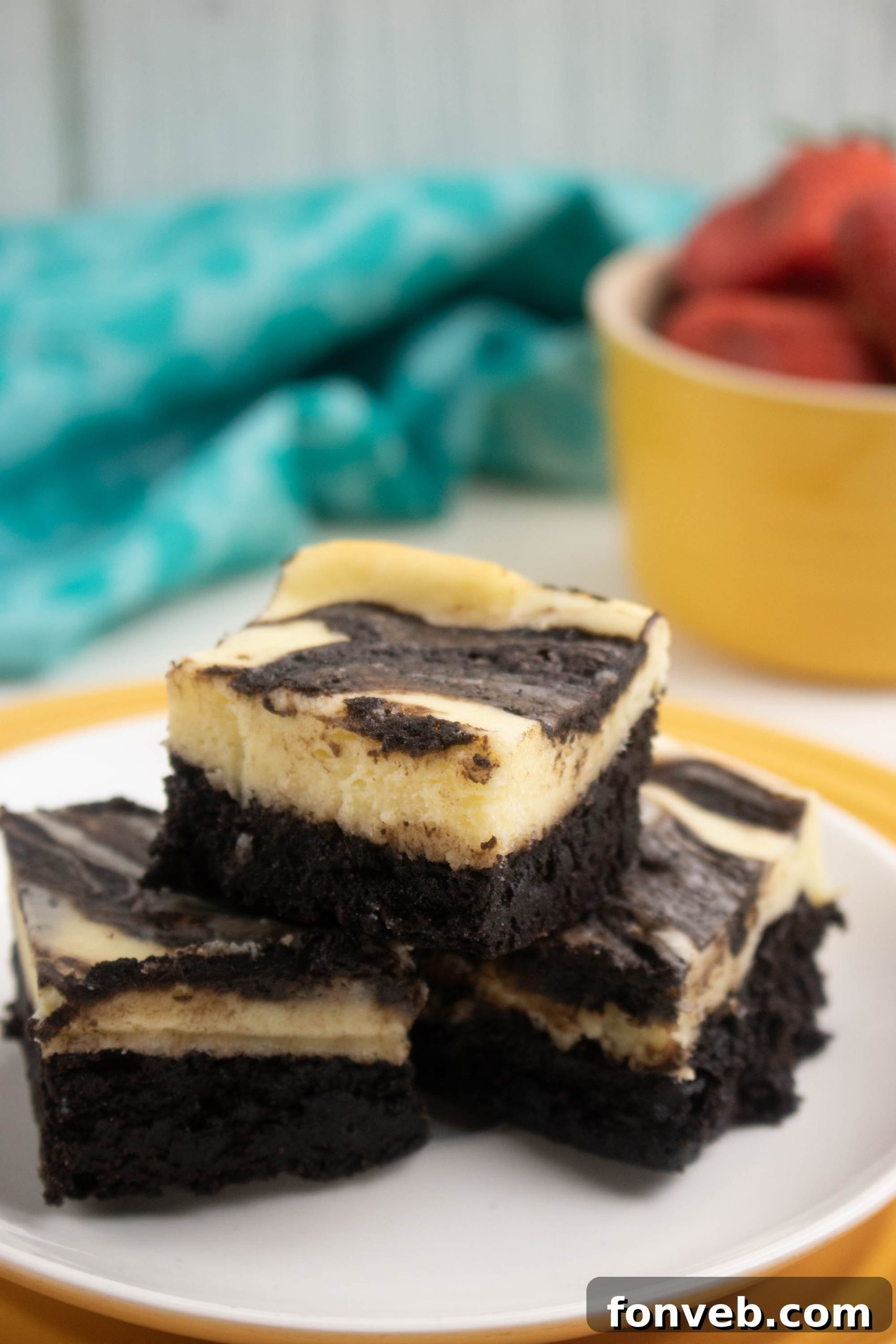 Two Cheesecake Swirl Brownies stacked, showcasing their thickness and the distinct swirl.