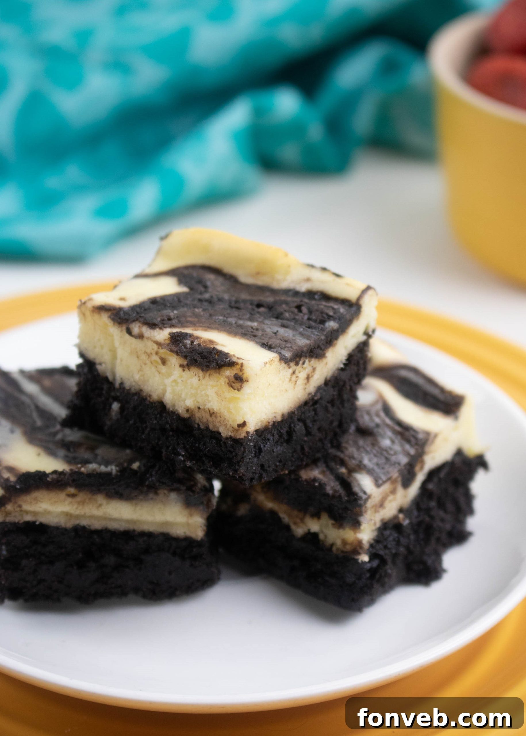 Several Cheesecake Swirl Brownies arranged on a serving platter, inviting guests to enjoy.