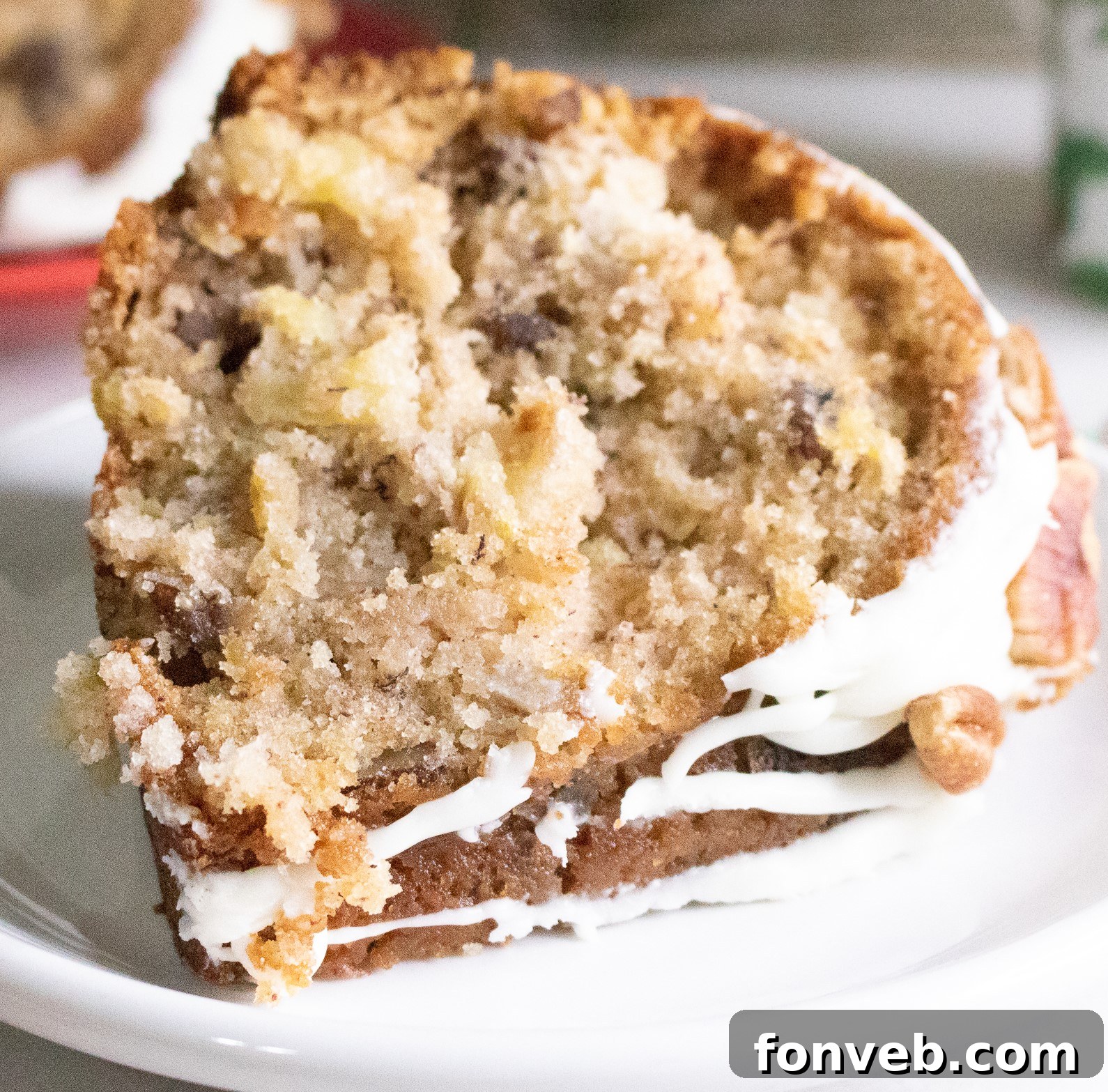 Moist Southern Hummingbird Bundt Cake slice on a white plate, showcasing its fluffy texture and pecan pieces